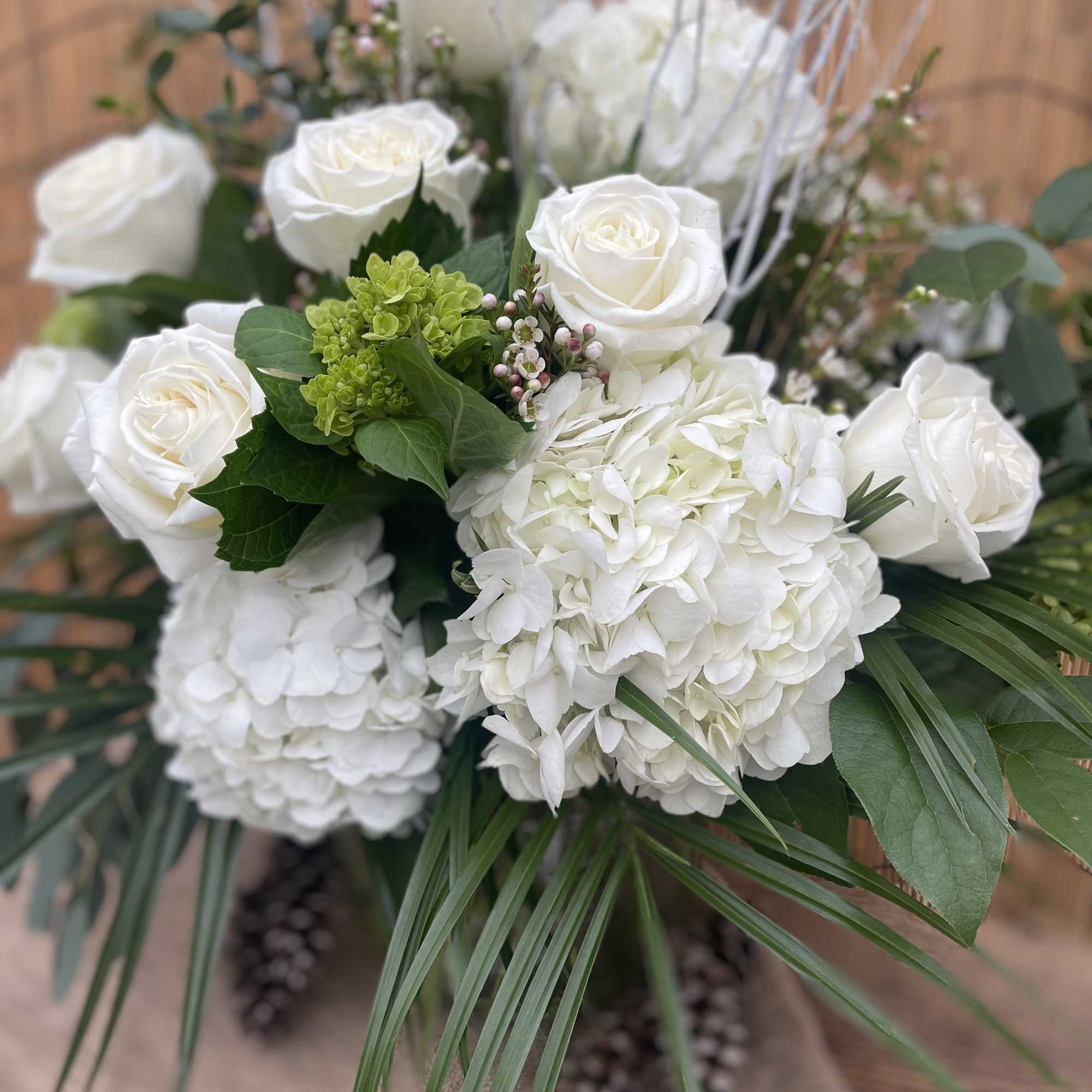 White roses and hydrangeas arranged with green foliage