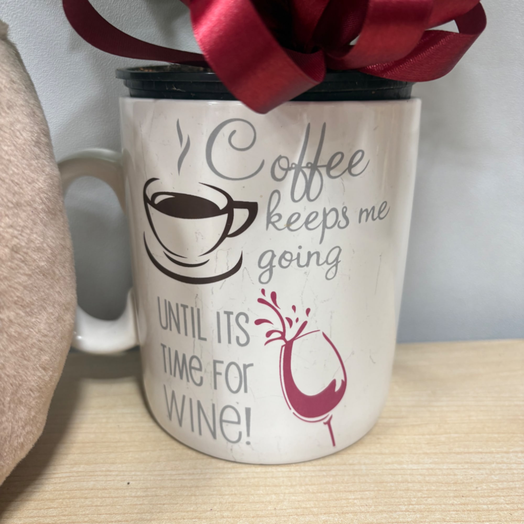 Coffee-themed mug with a red bow and printed text about coffee and wine