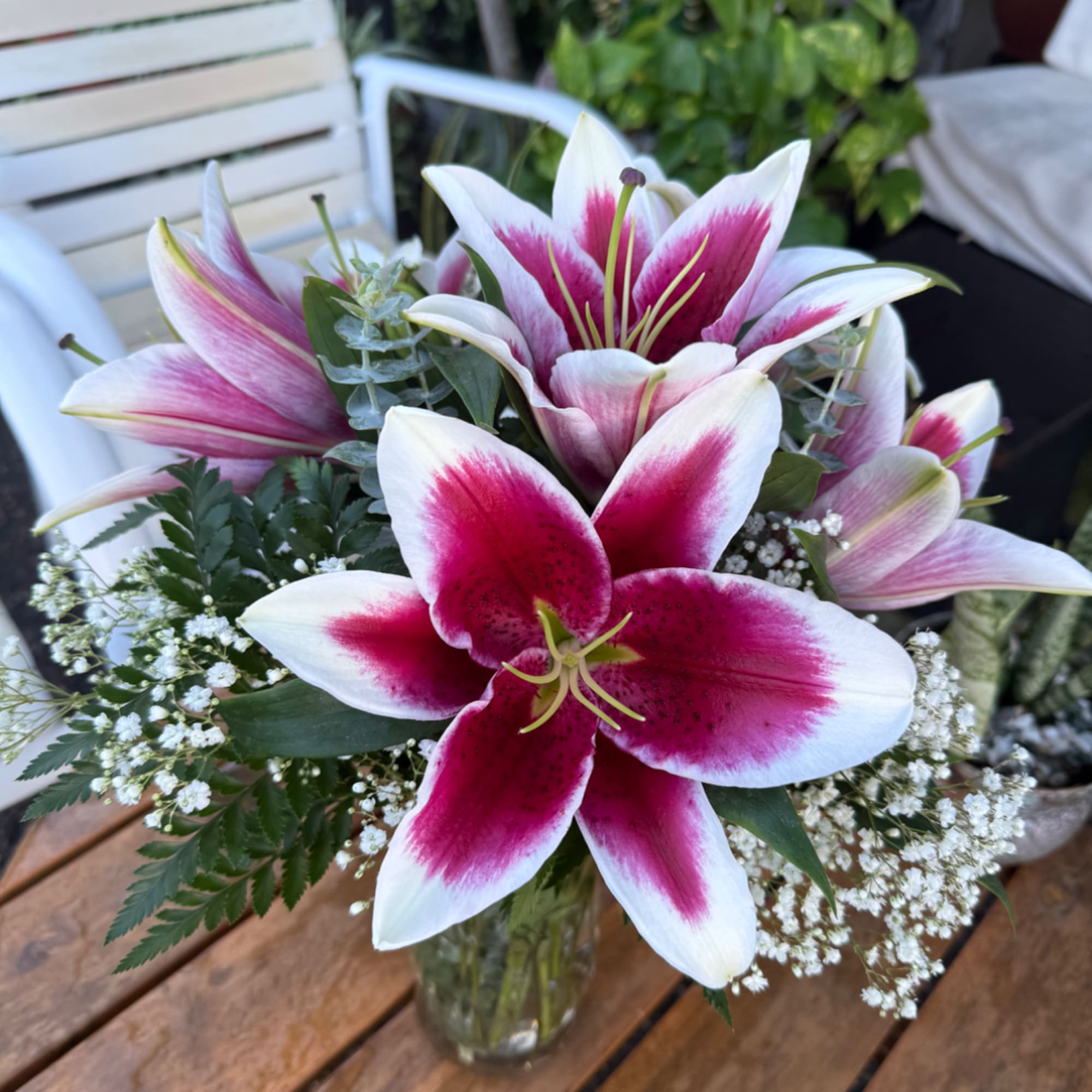 Pink and white lilies arranged in a glass vase