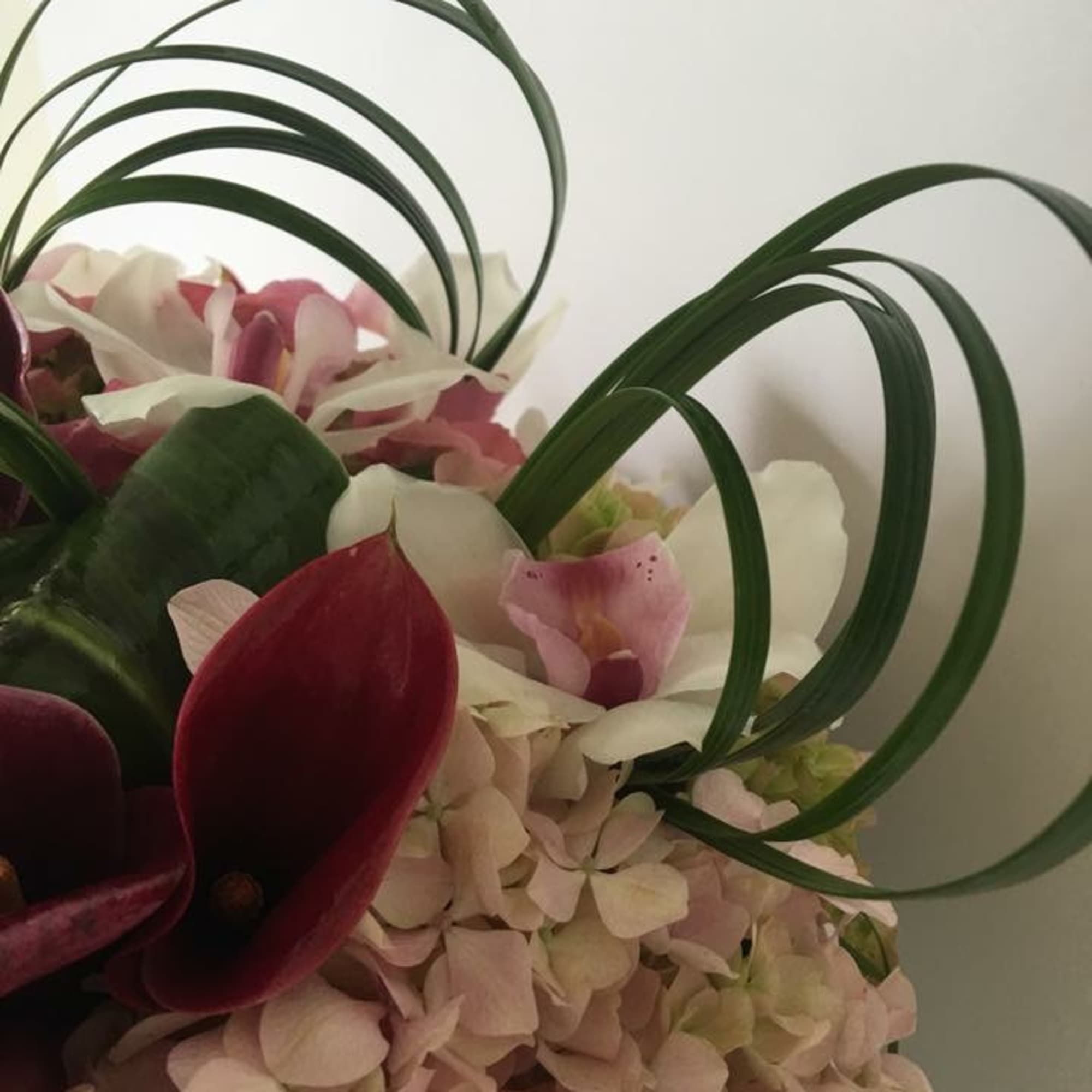 Pink and white floral arrangement with curved green loops