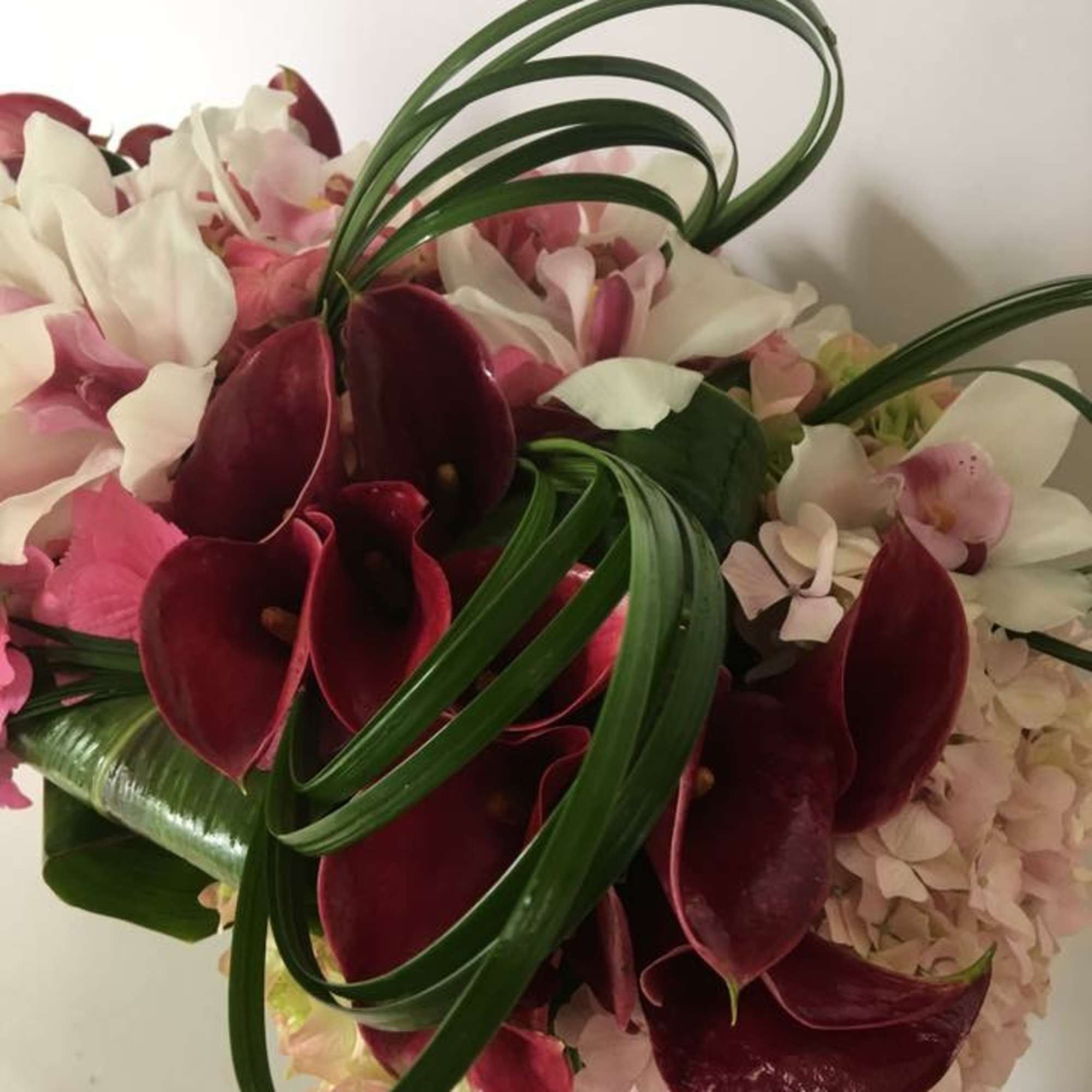 Bouquet of burgundy calla lilies and pale pink flowers