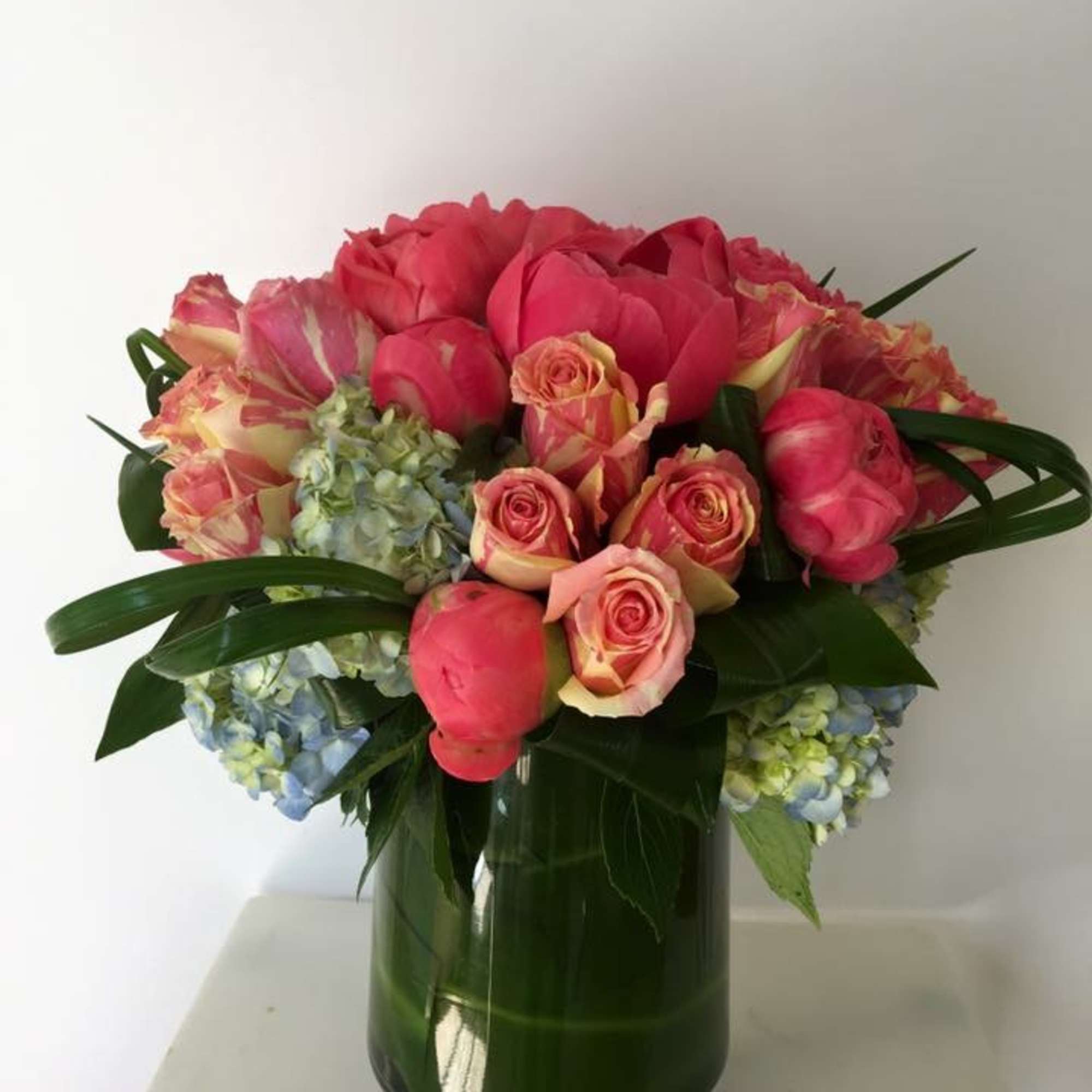 Pink roses and hydrangeas arranged in a green glass vase, photo 3 of 3