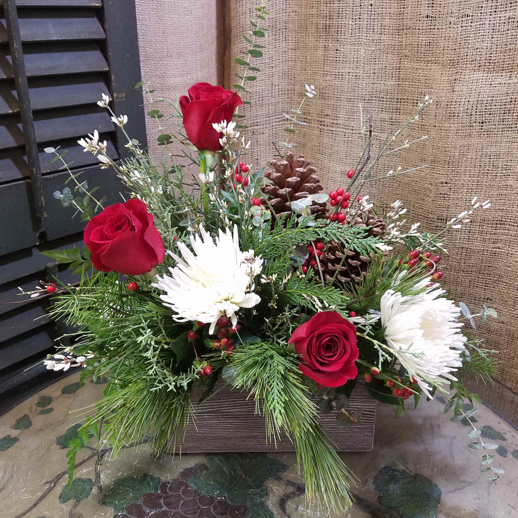Red roses and white chrysanthemums in a rustic wooden box