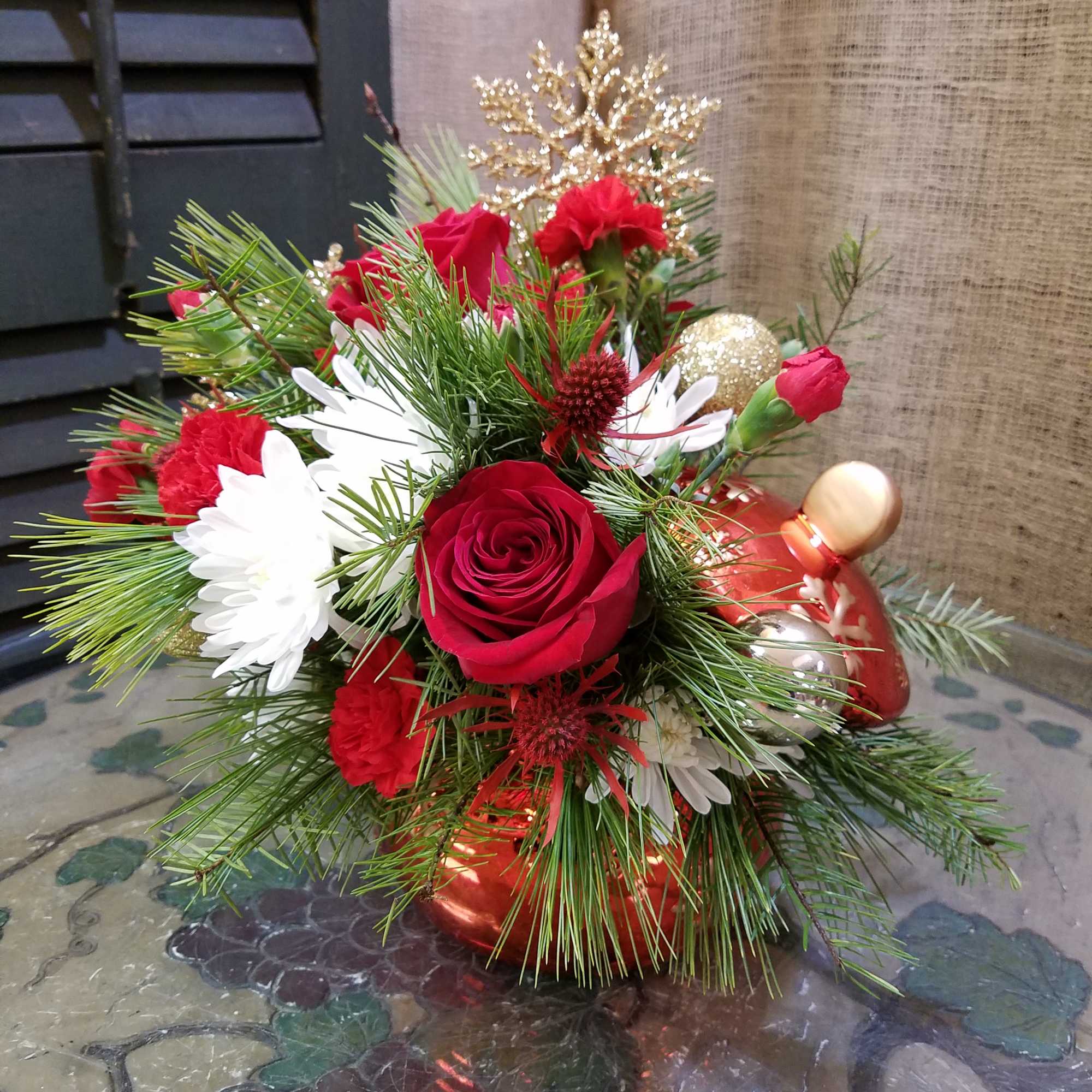 Red roses and white daisies in a festive holiday arrangement