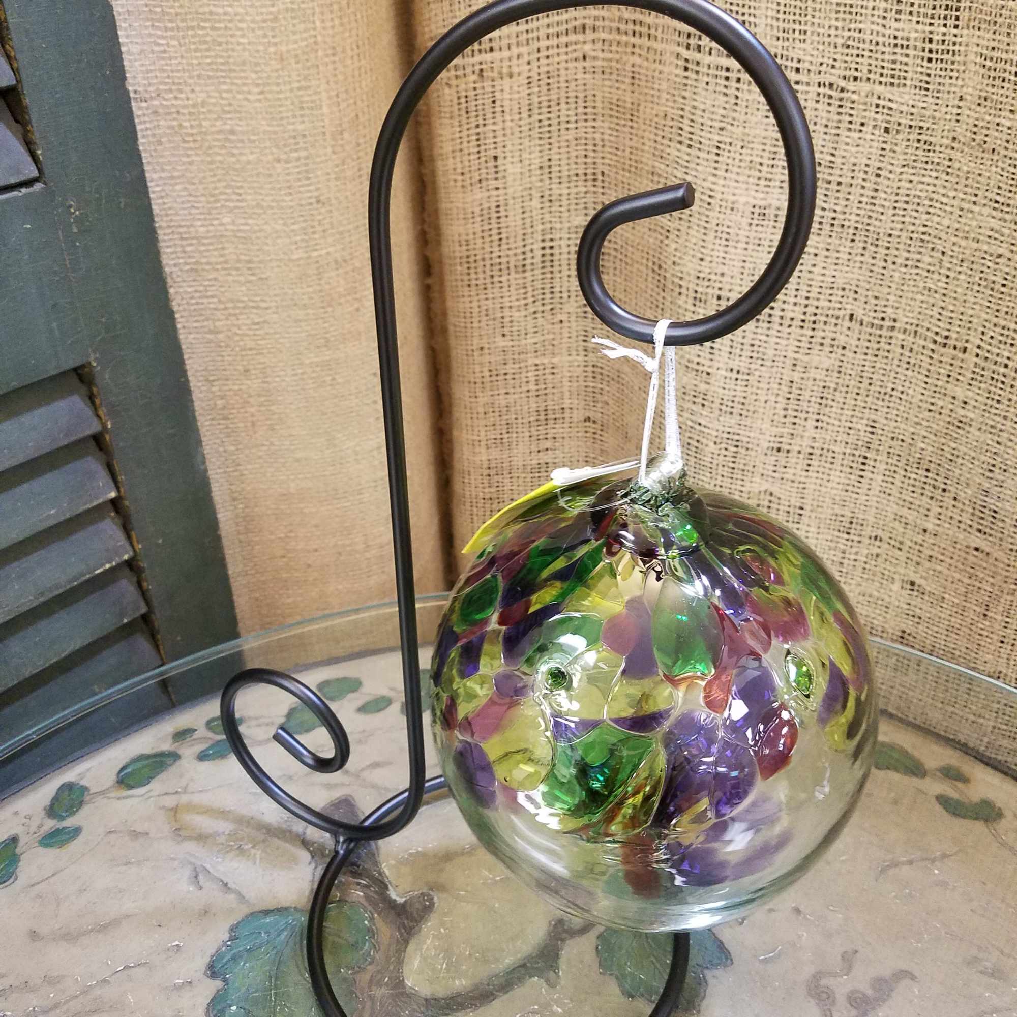 Decorative glass orb ornament on a black metal stand