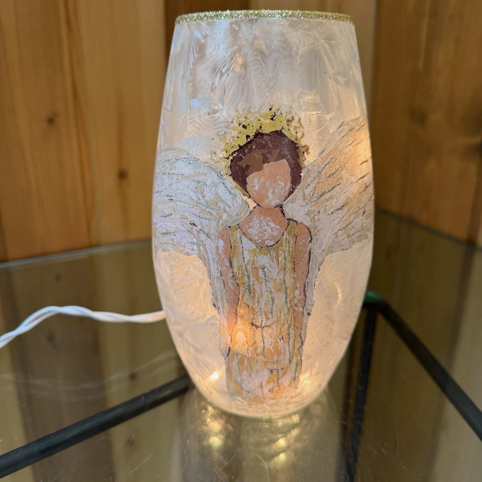Decorative glass lamp with an angel figure inside