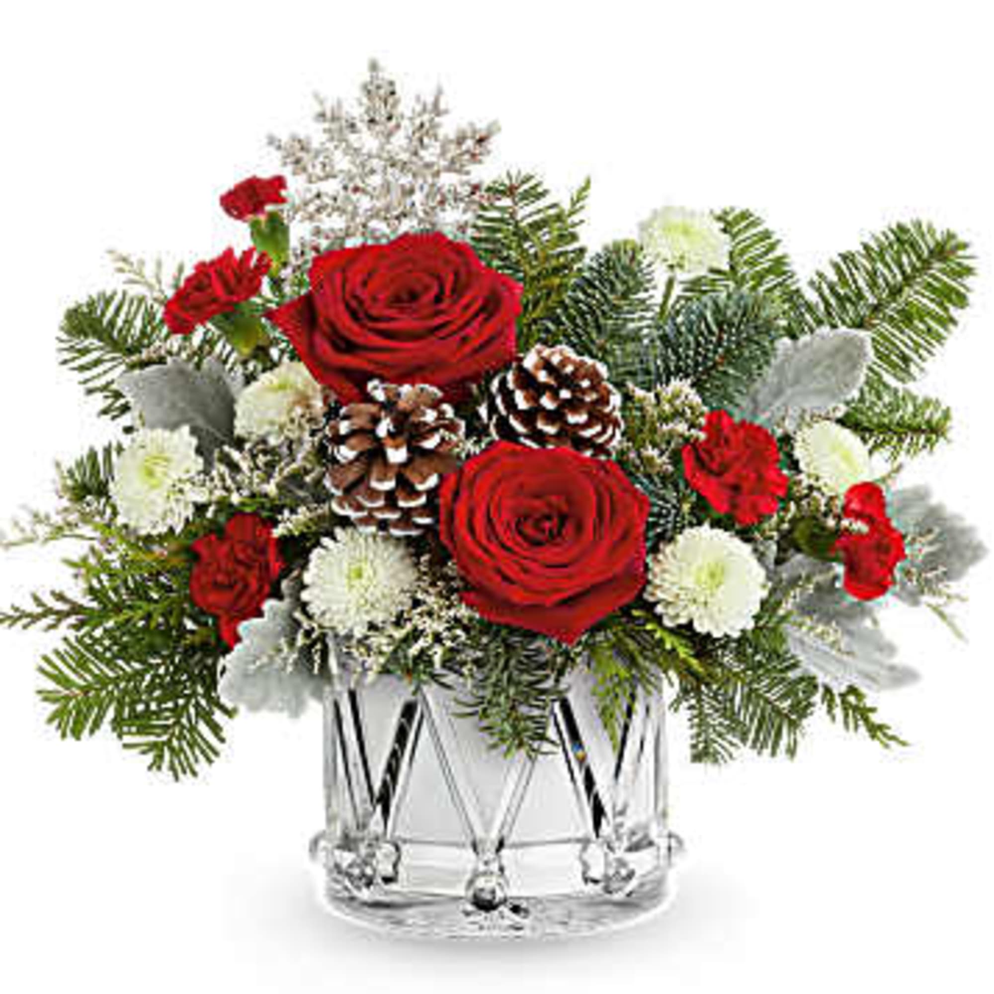 Red roses and white flowers in a clear glass vase with pinecones