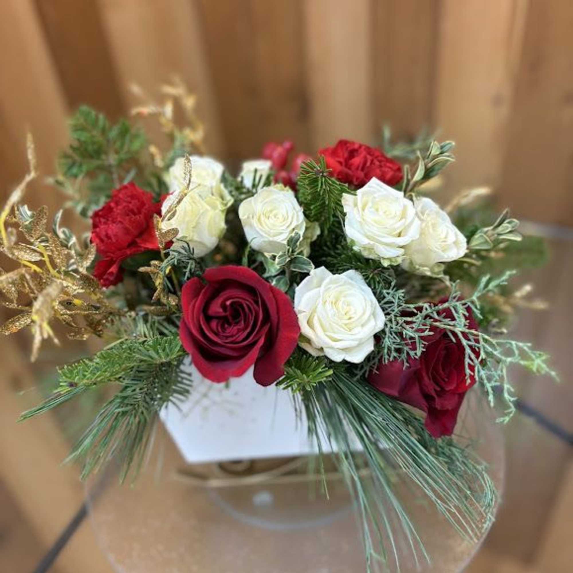 Red and white roses arranged in a clear round vase