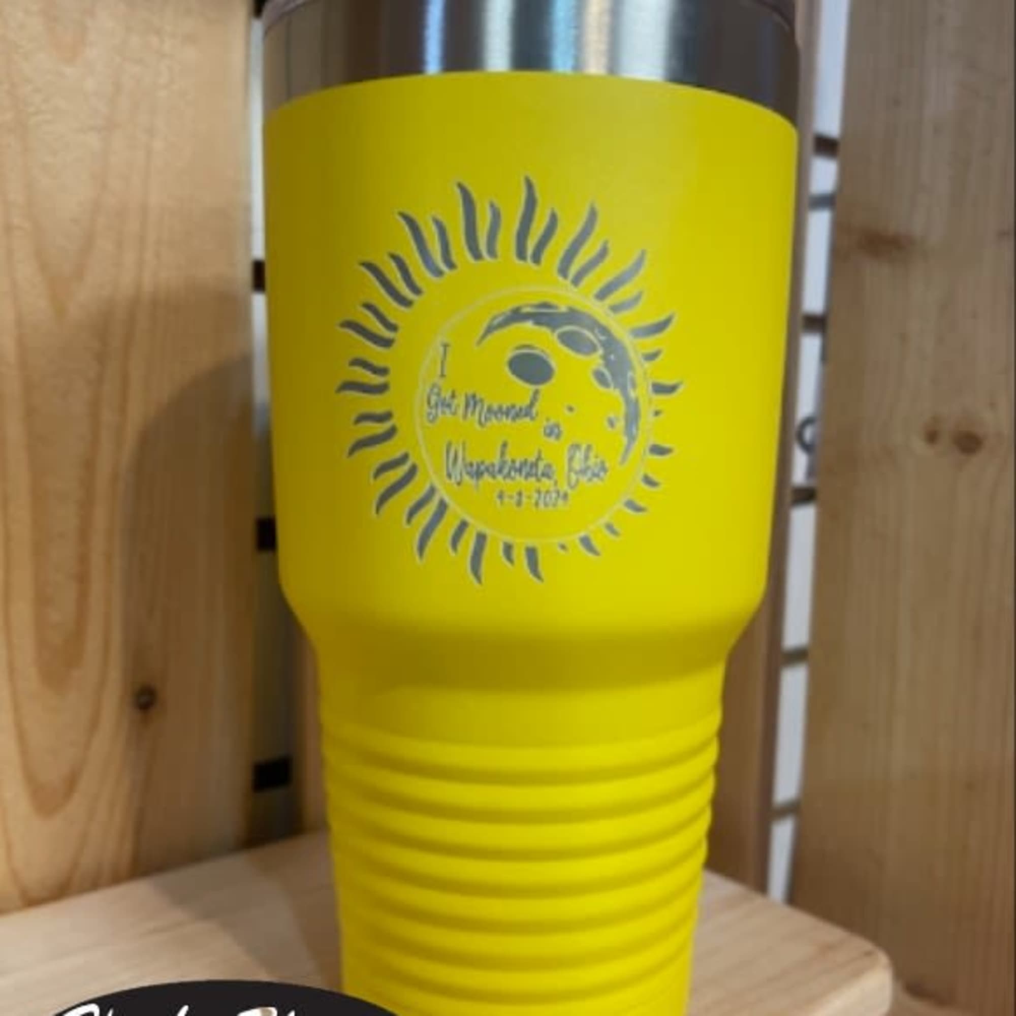 Yellow insulated tumbler with a silver lid and printed sun design