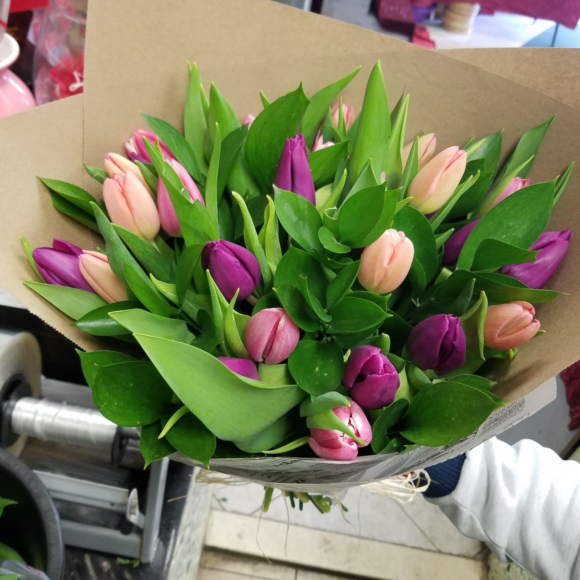 Bouquet of pink and purple tulips wrapped in brown paper
