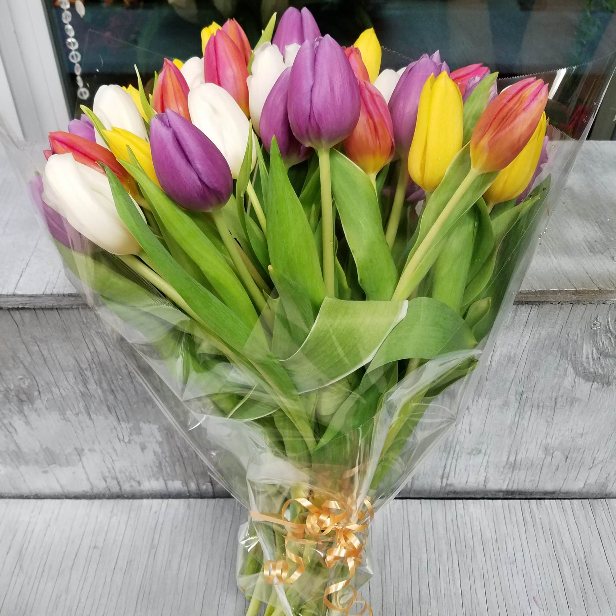 Bouquet of multicolored tulips wrapped in clear plastic