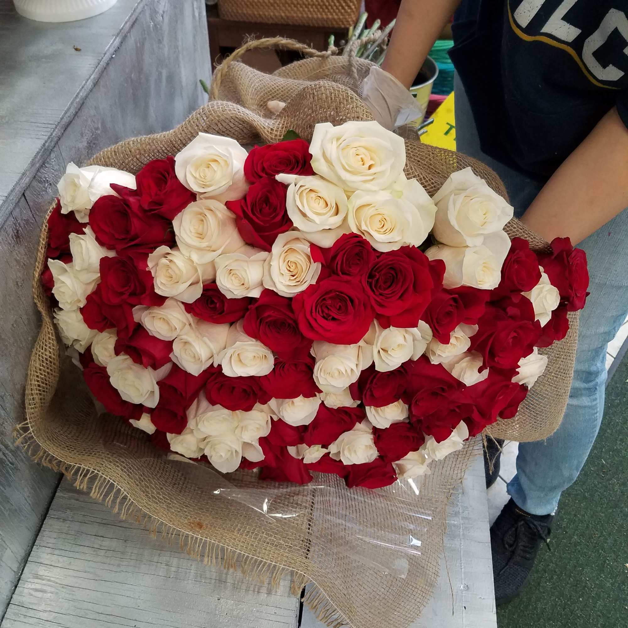 Large bouquet of red and white roses wrapped in burlap