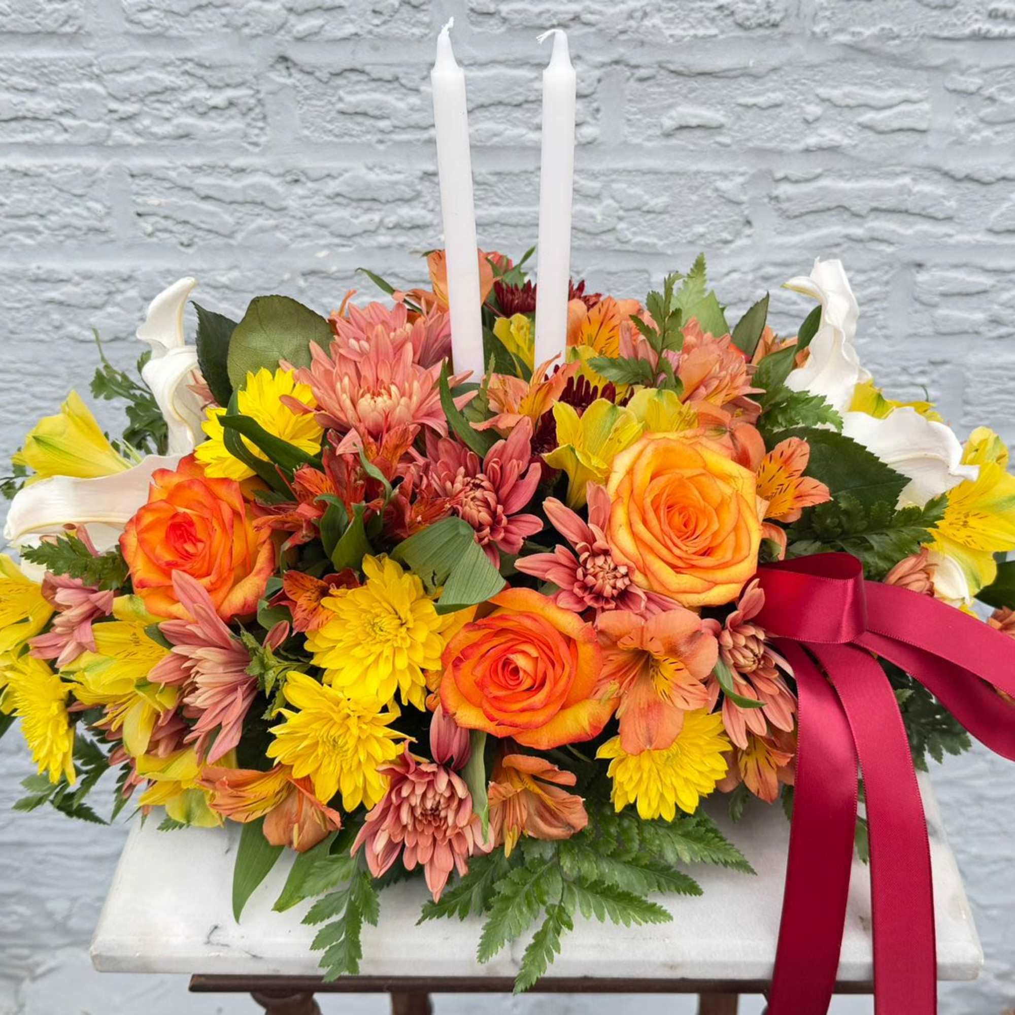 &ldquo;This stunning centerpiece is handcrafted with fresh flowers and accented with an