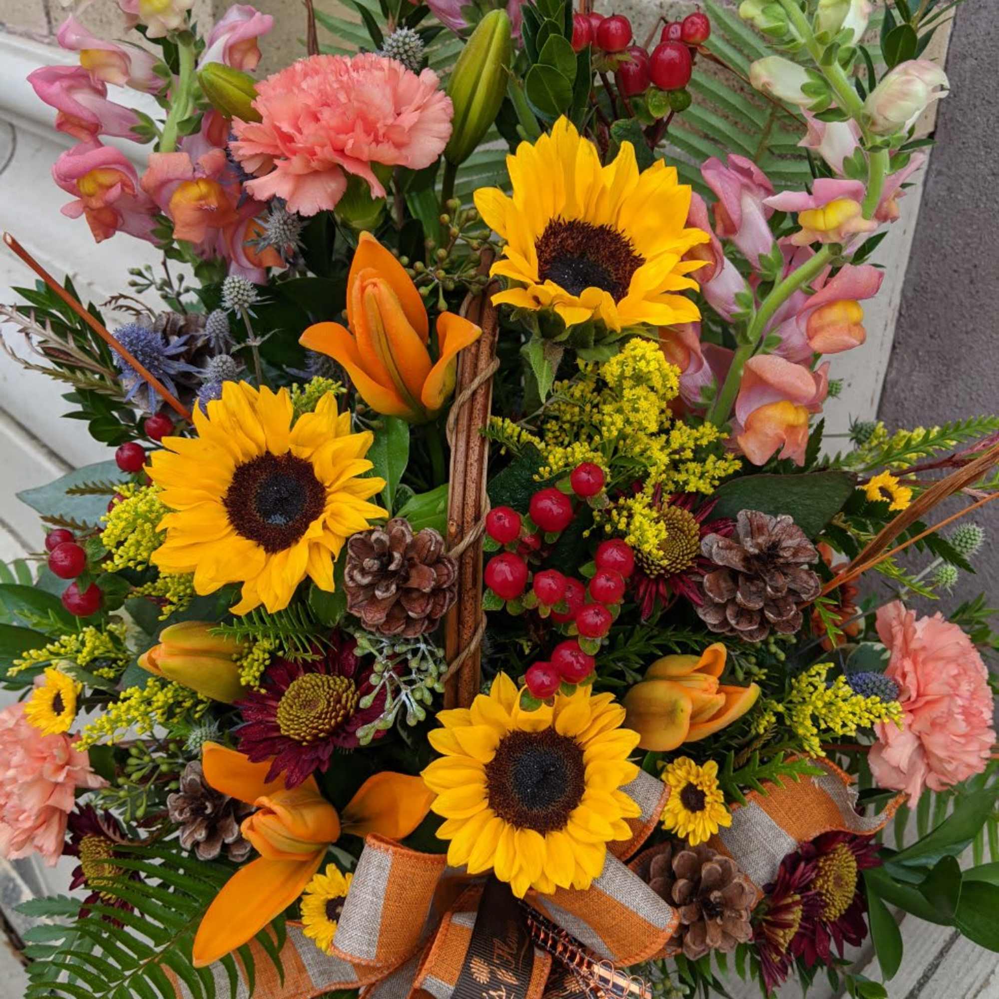 Colorful autumn bouquet with sunflowers, orange lilies, and pink snapdragons
