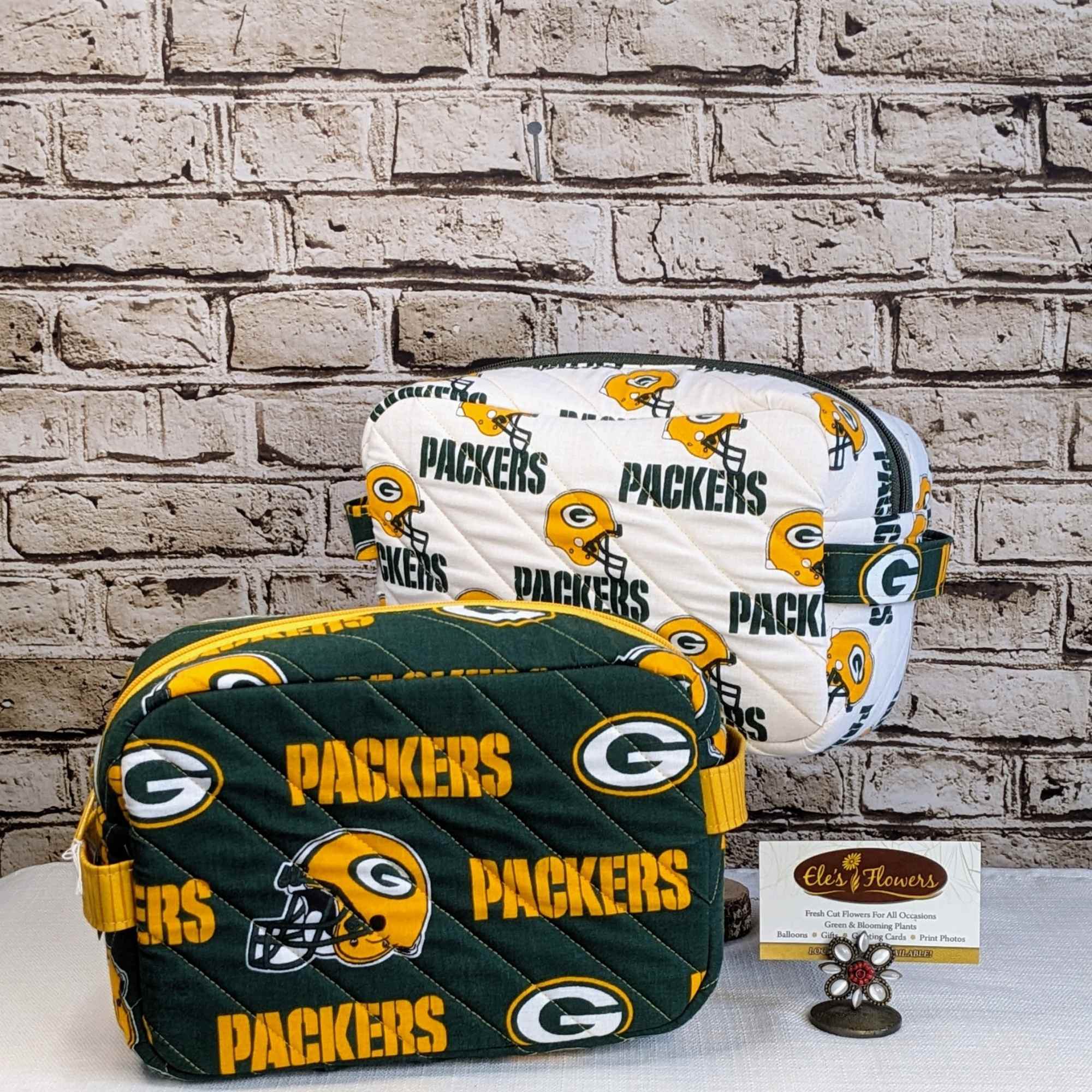 Two Green Bay Packers quilted zip pouches on a table
