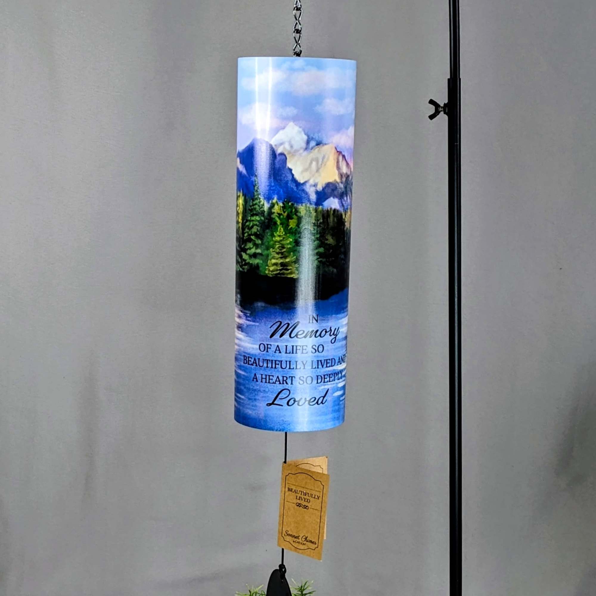 Hanging memorial wind chime with a mountain scene and printed tribute text