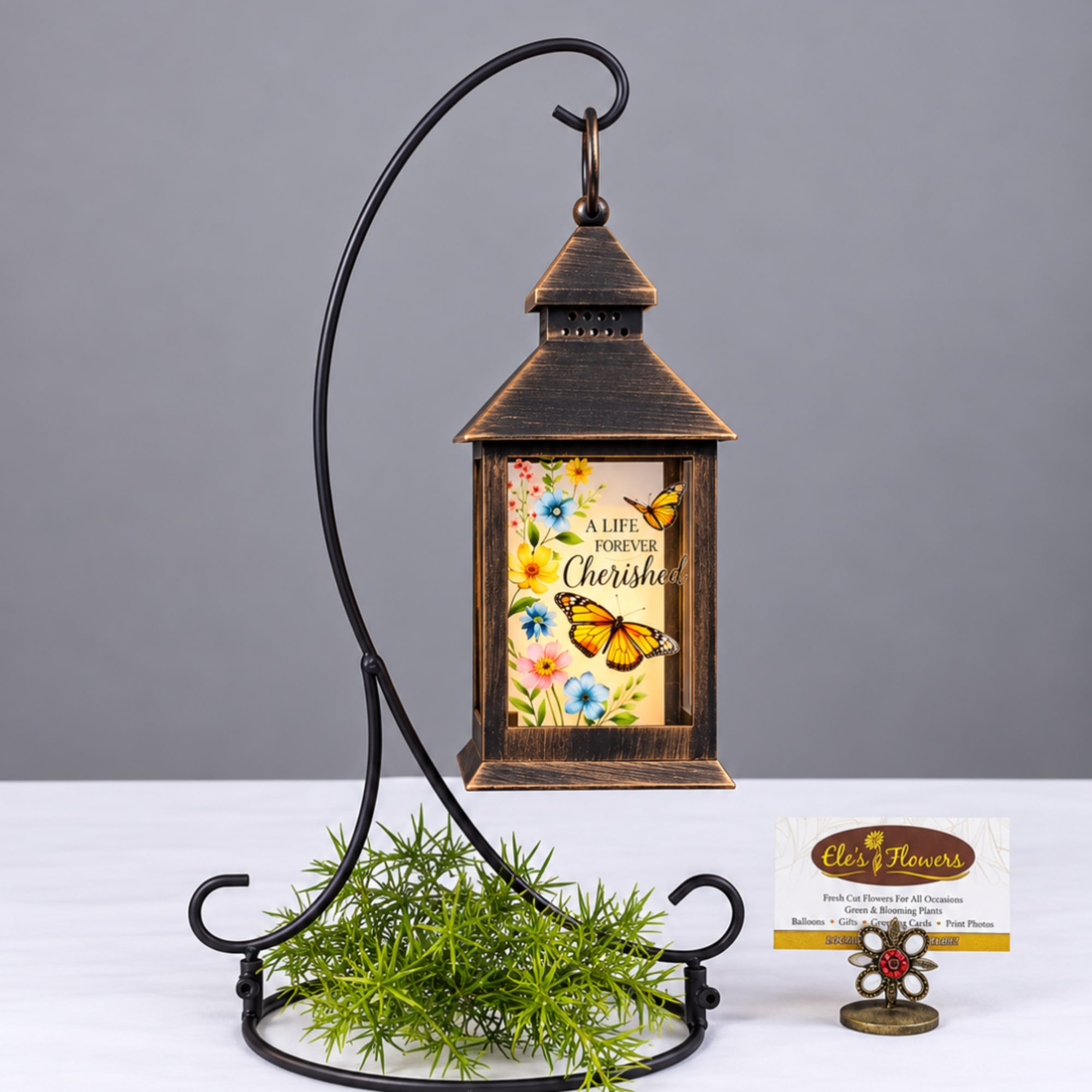 Decorative lantern with butterfly artwork on a metal stand