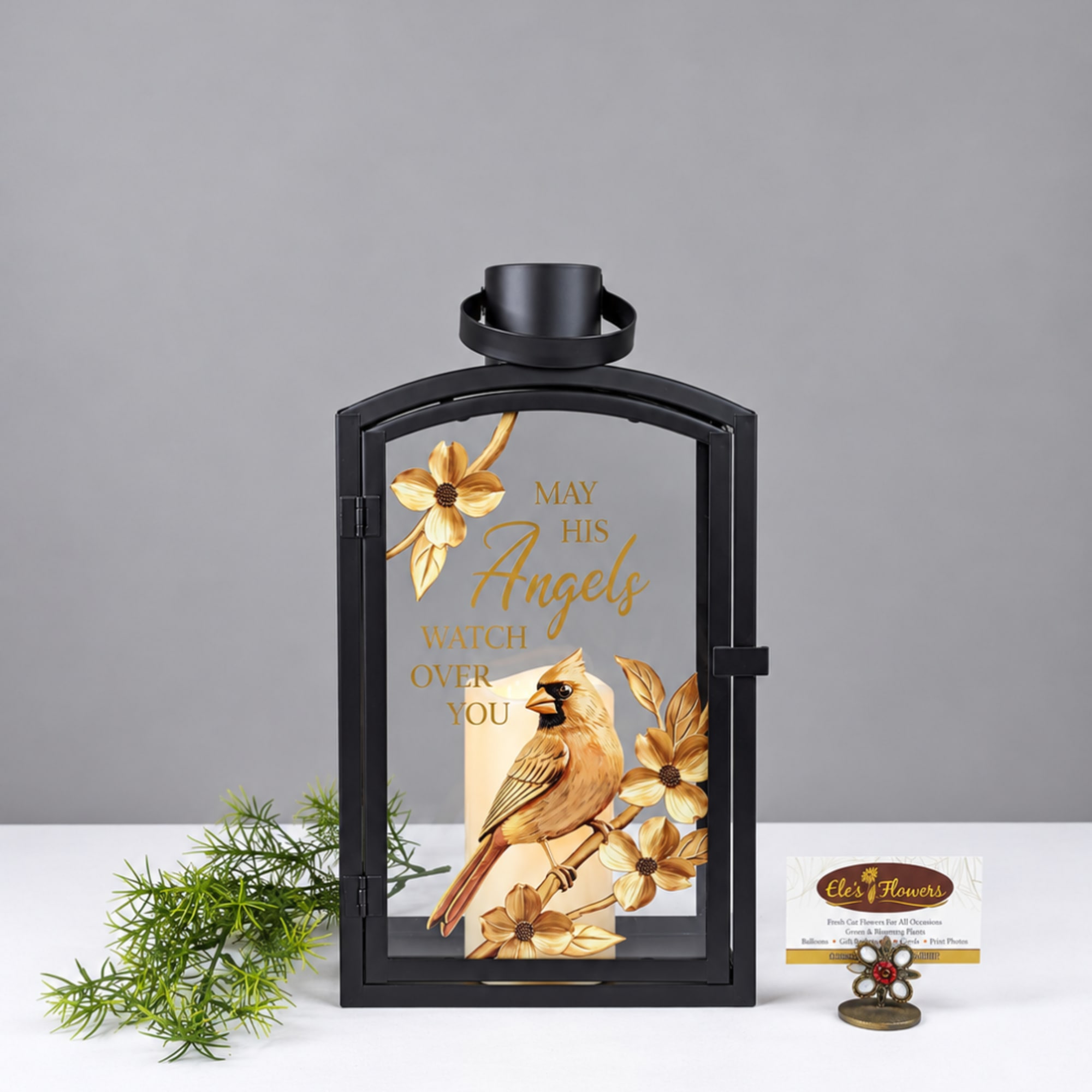 Black lantern with a cardinal and gold floral design, plus a candle inside