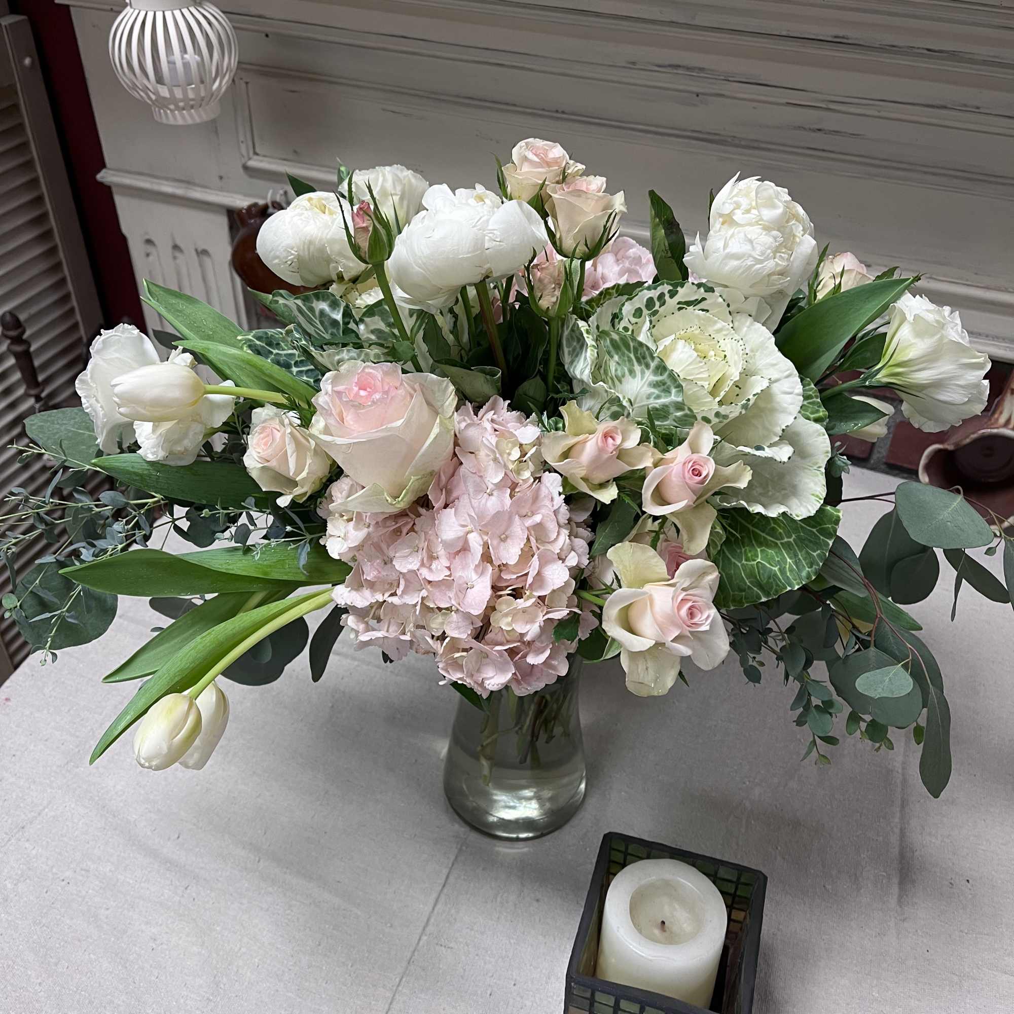 Pastel floral arrangement in a glass vase with roses, tulips, and hydrangea