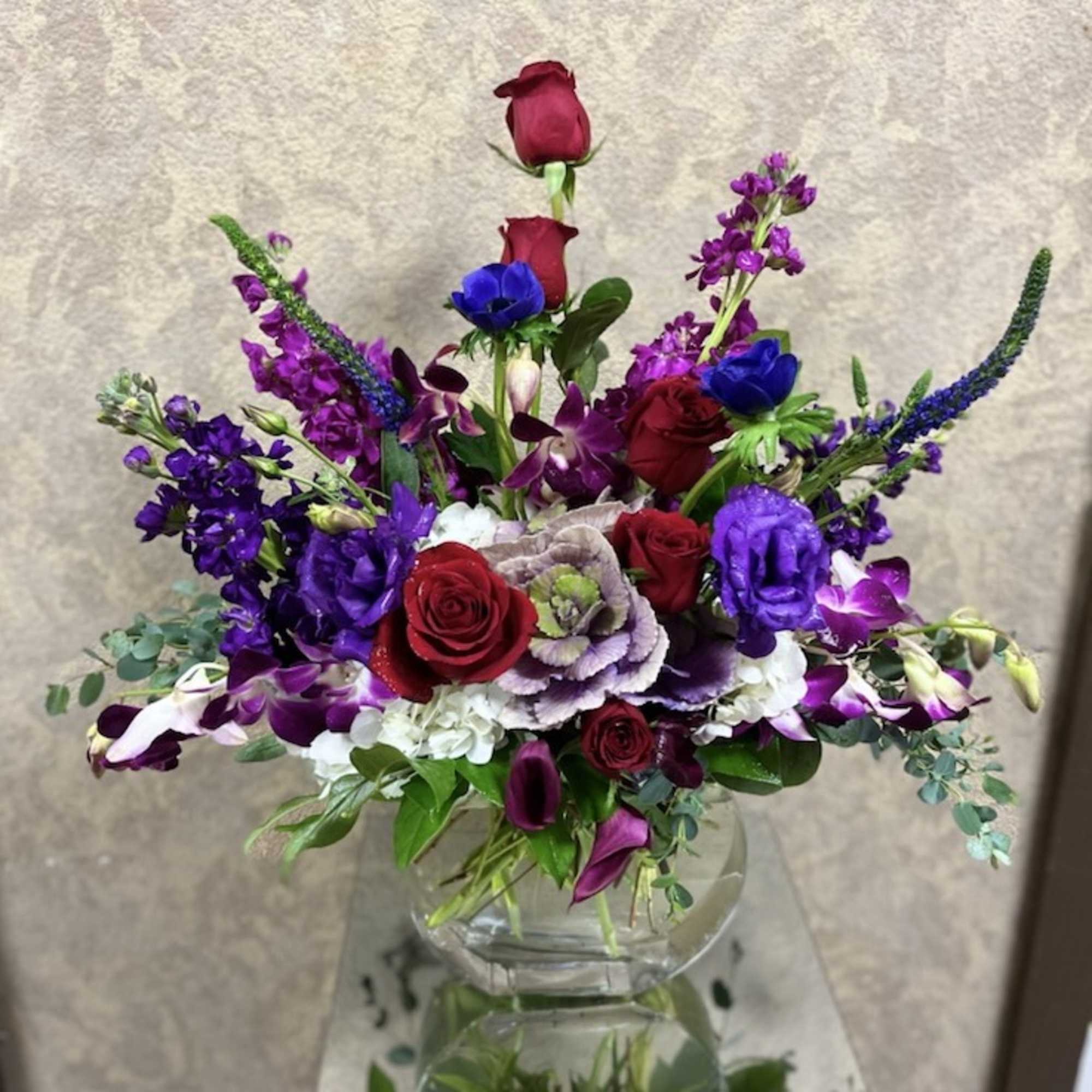 Mixed bouquet of red, purple, and white flowers in a clear glass vase, photo 2 of 2