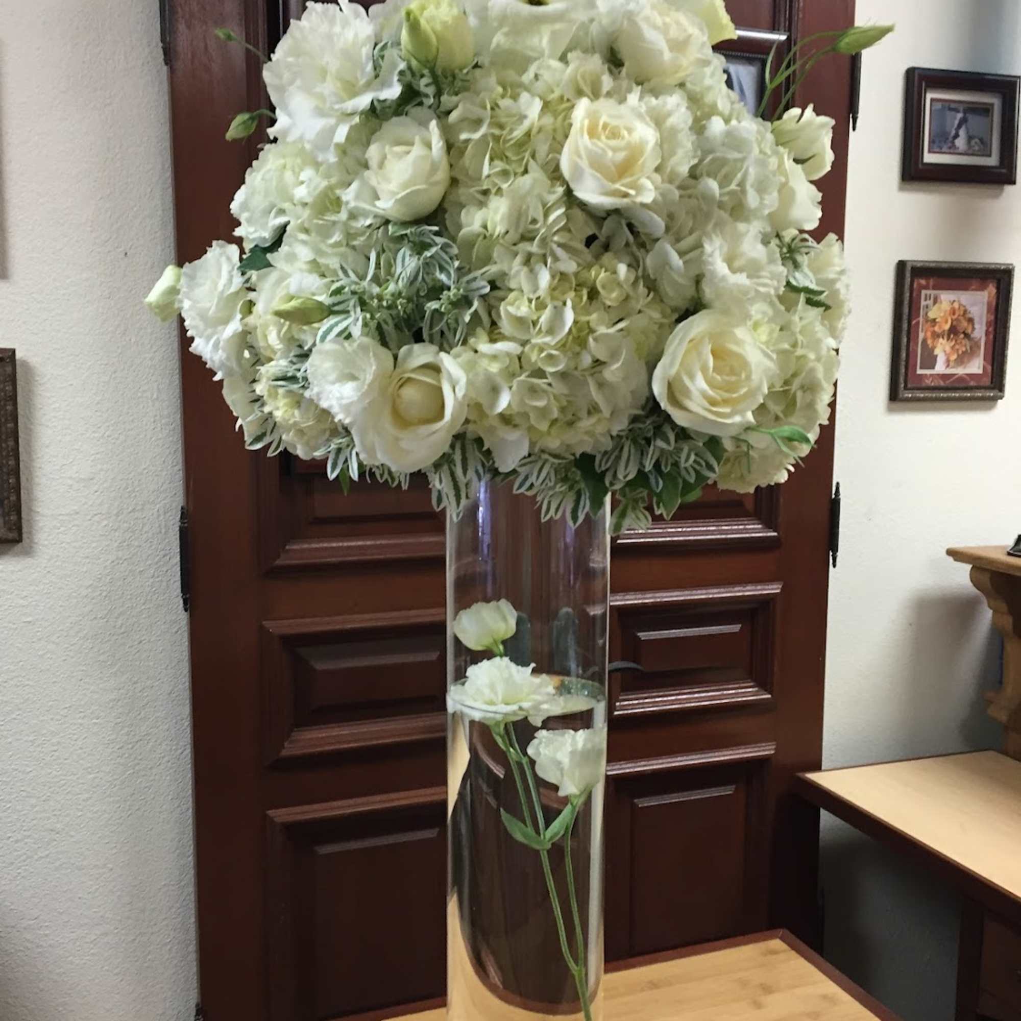 White floral arrangement in a tall clear glass vase