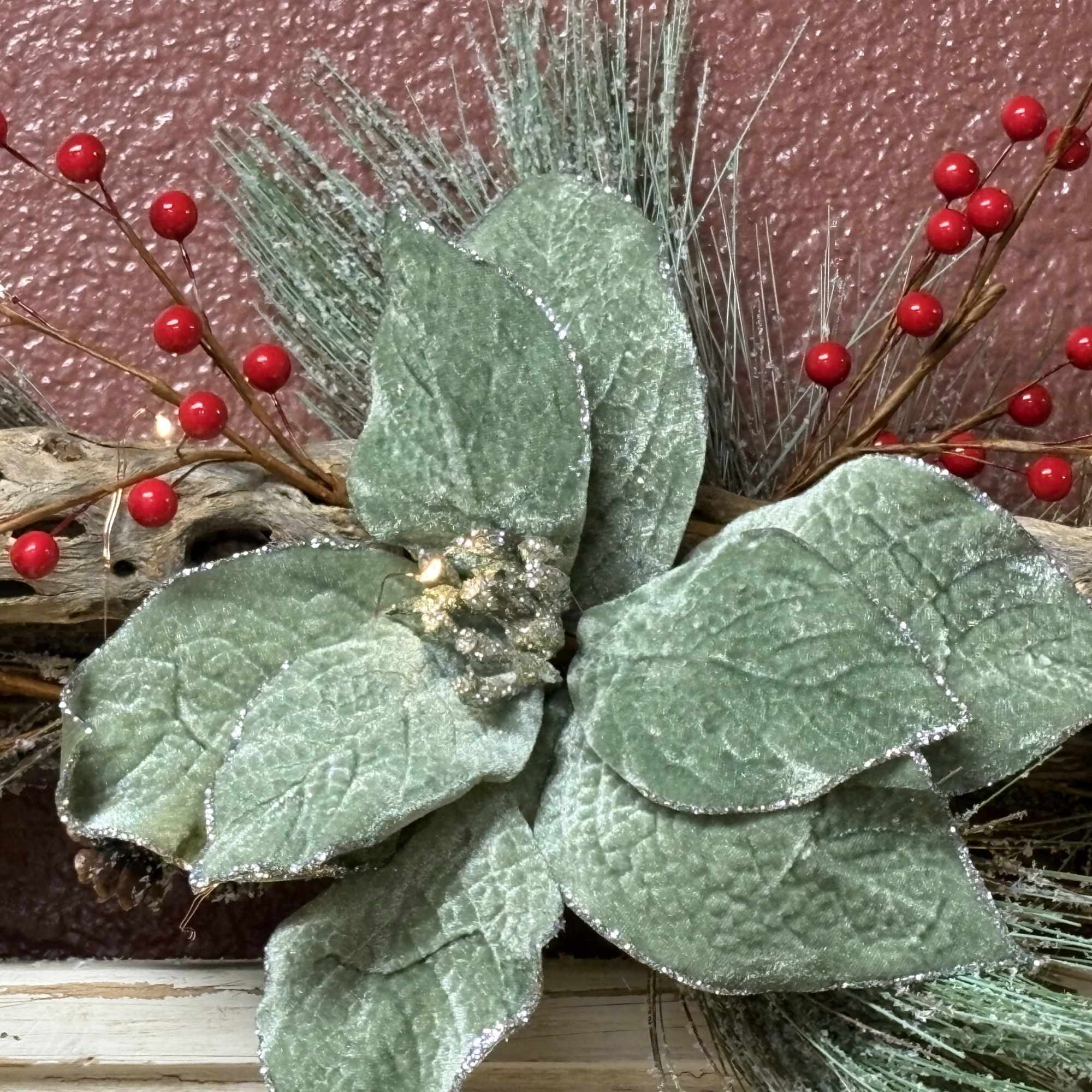 Decorative arrangement with frosted green leaves and red berry stems