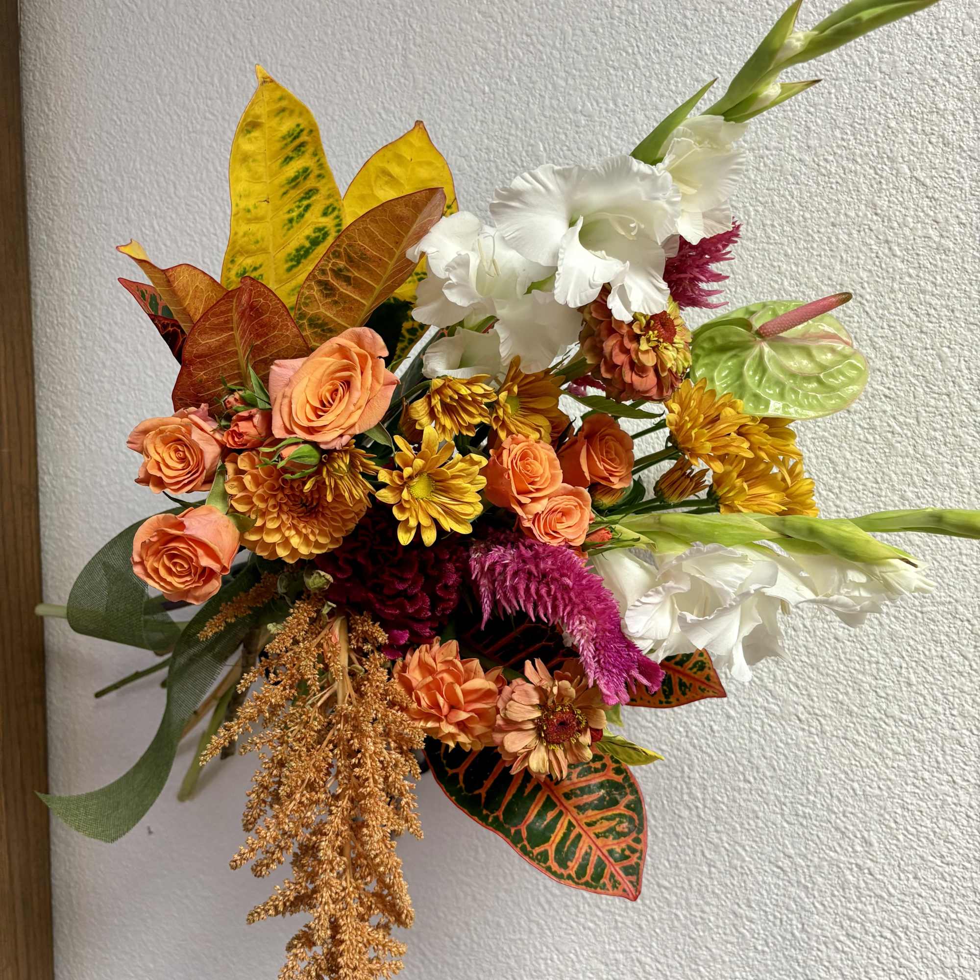 Colorful bouquet with orange roses, white gladiolus, and yellow mums