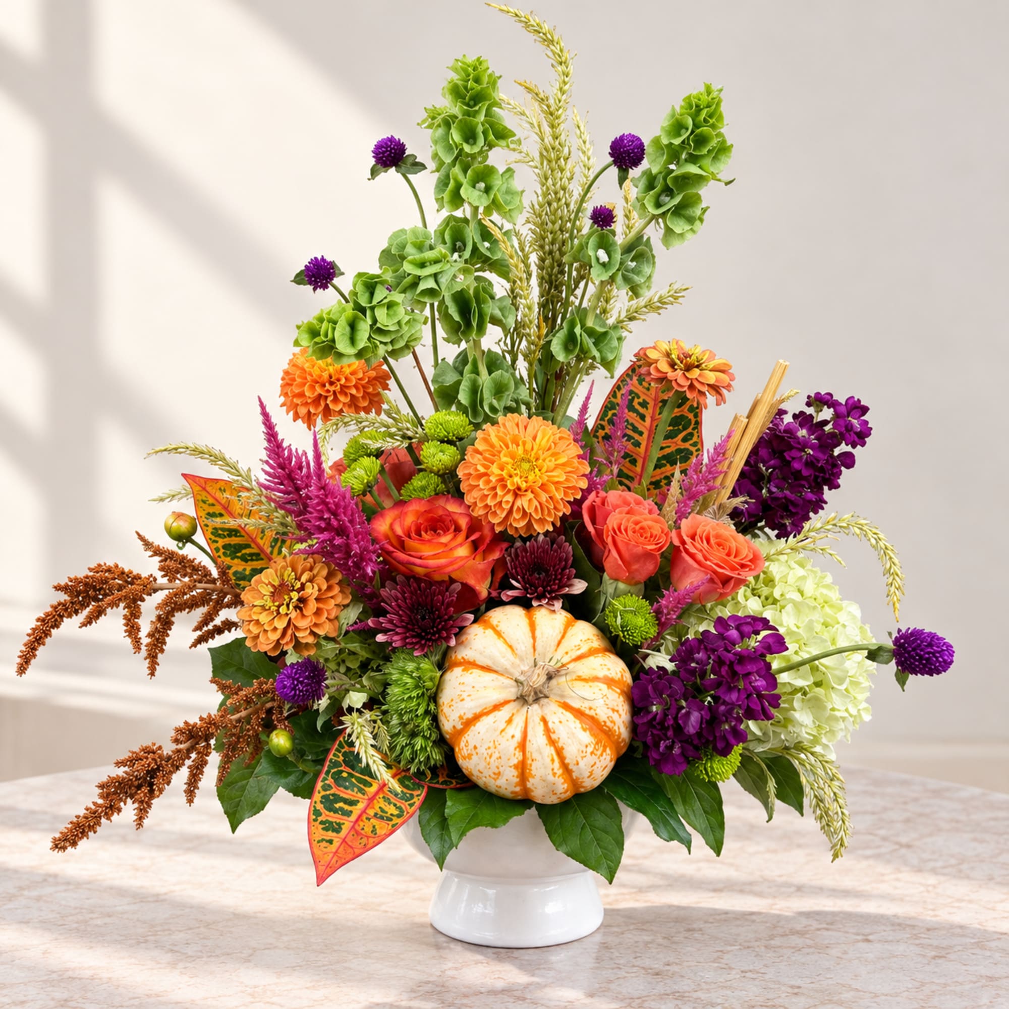 Autumn floral arrangement with a white pumpkin in a white vase