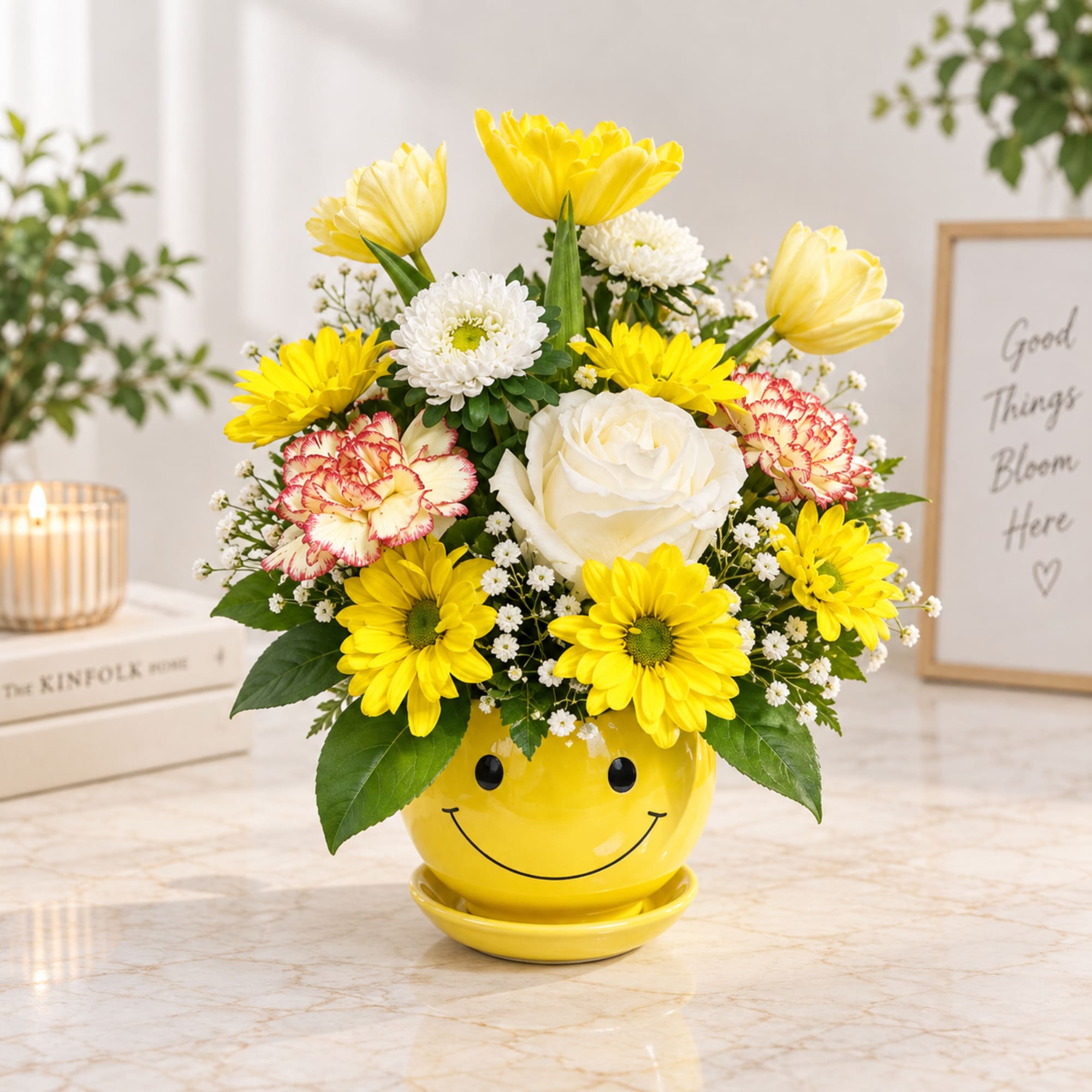 Yellow and white flower arrangement in a smiley-face pot