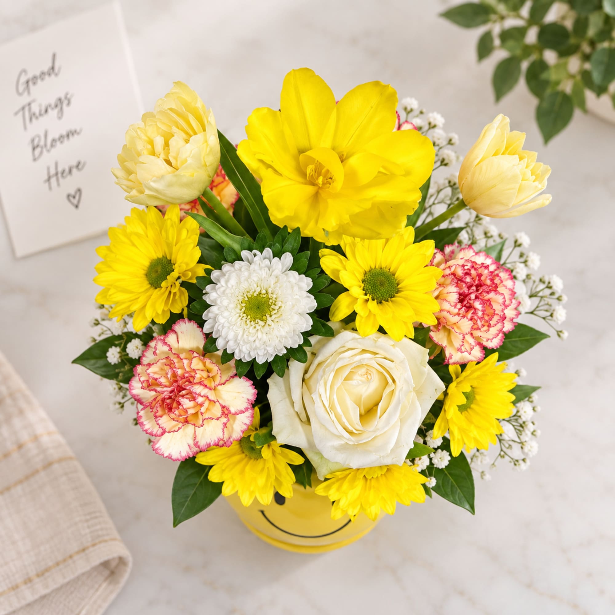 Yellow and white mixed flower arrangement in a yellow vase