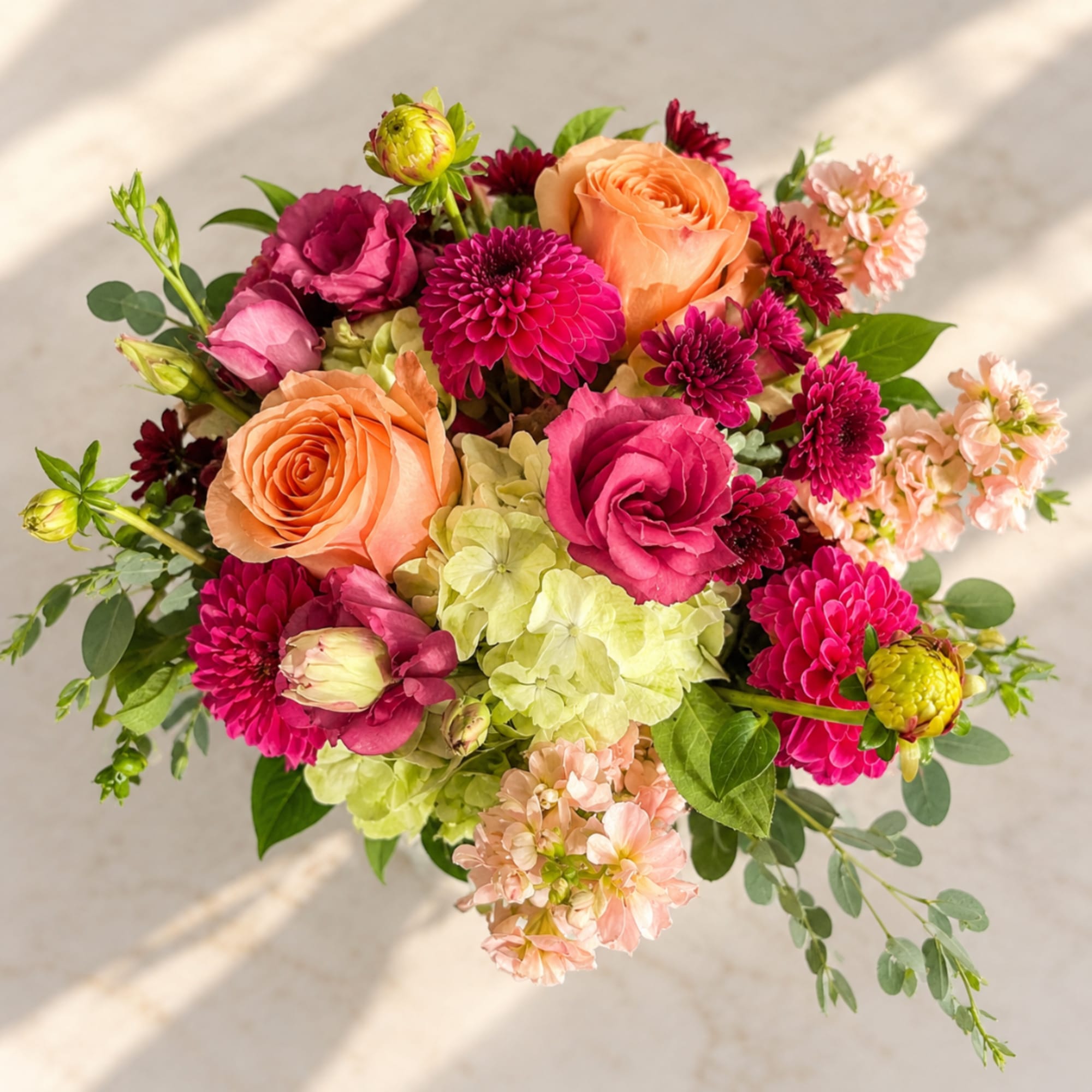 Bouquet of peach roses, pink dahlias, and pale hydrangeas