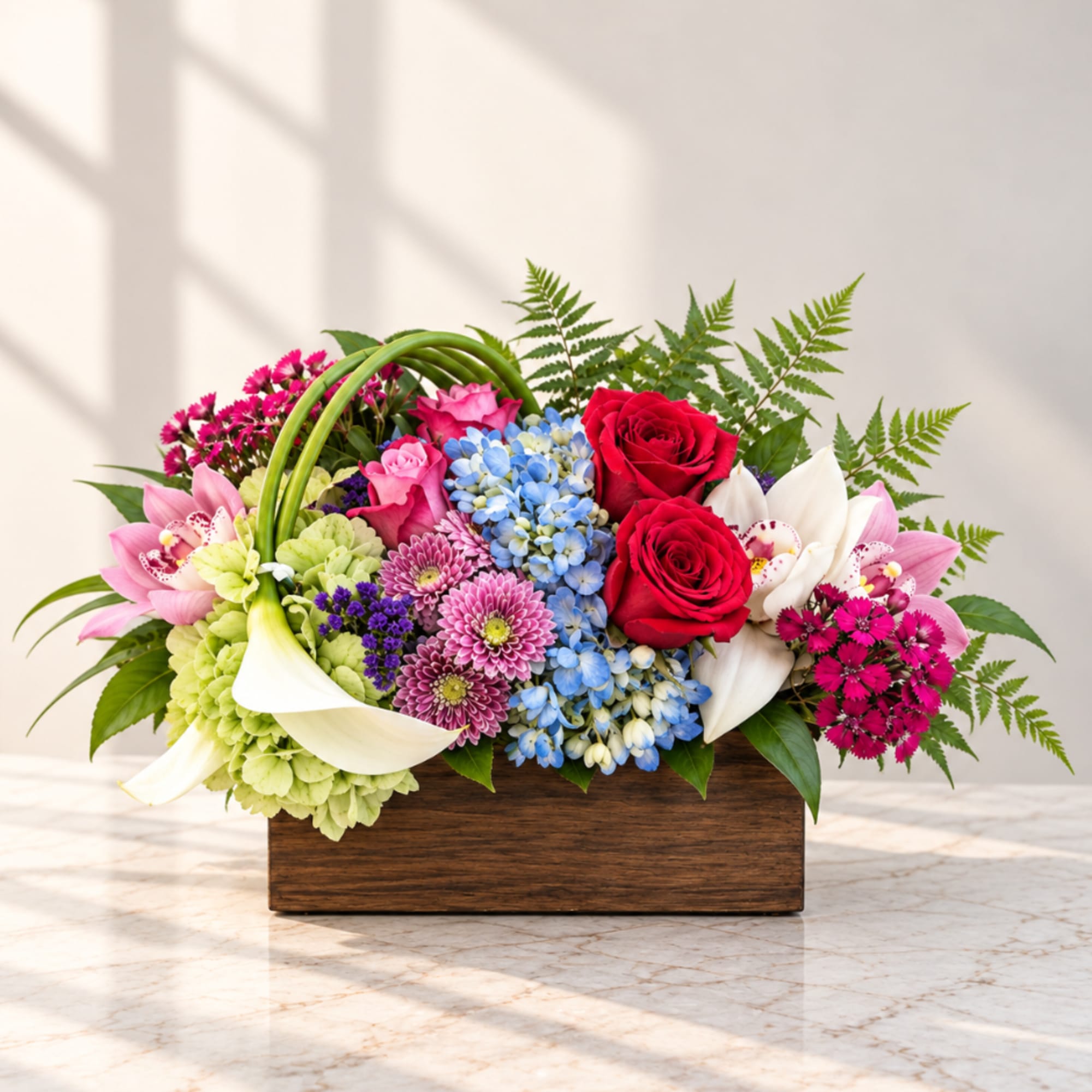 Mixed bouquet with roses, hydrangeas, lilies, and calla lilies in a wooden box