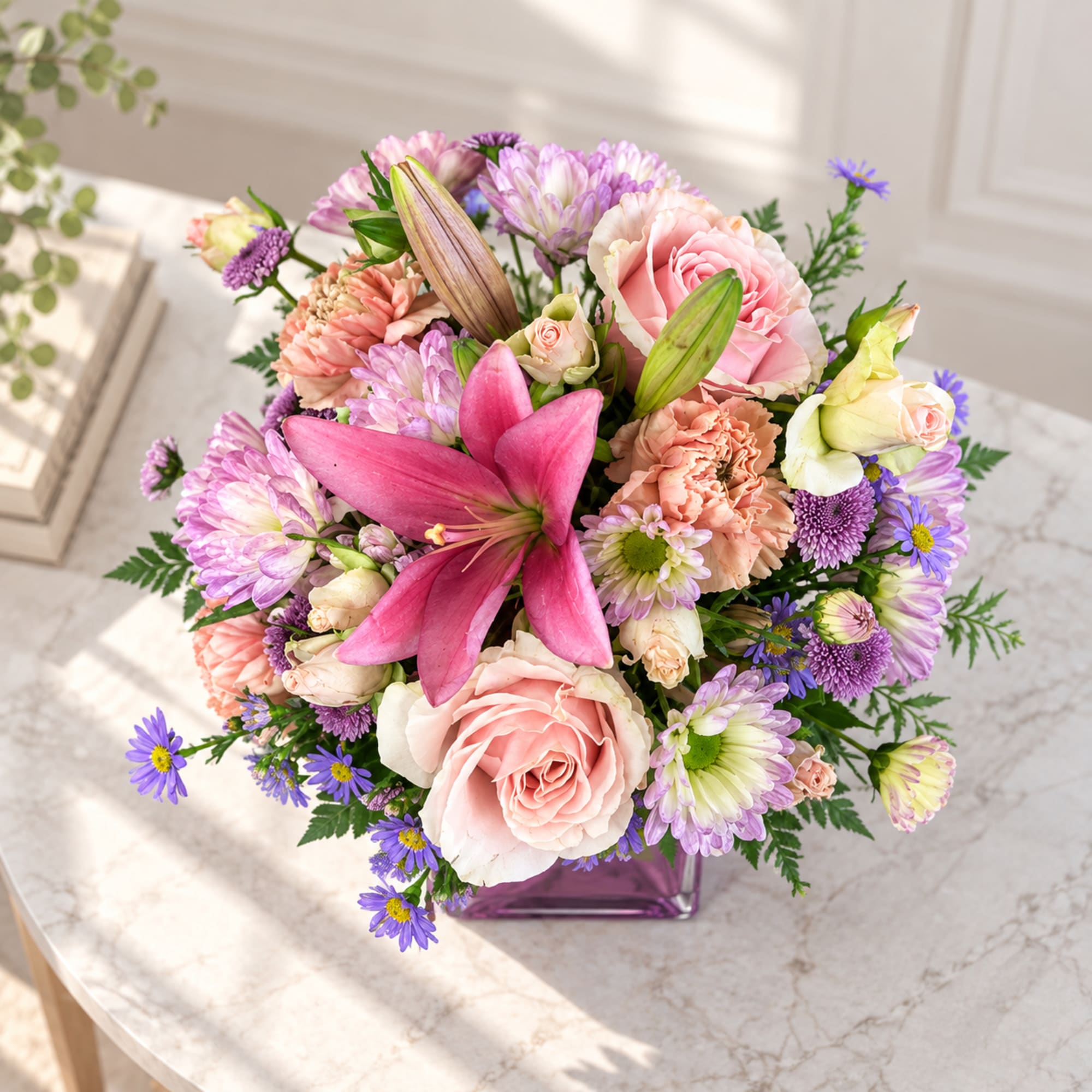 Mixed pink and purple bouquet in a purple glass vase