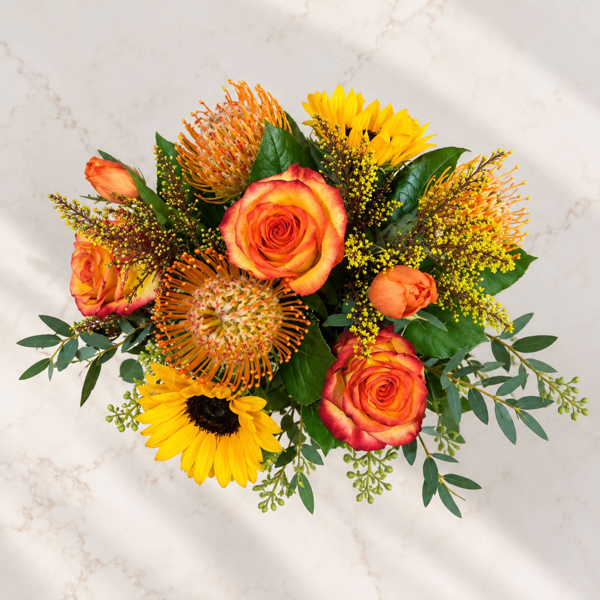 Bouquet of orange roses and yellow sunflowers with mixed greenery