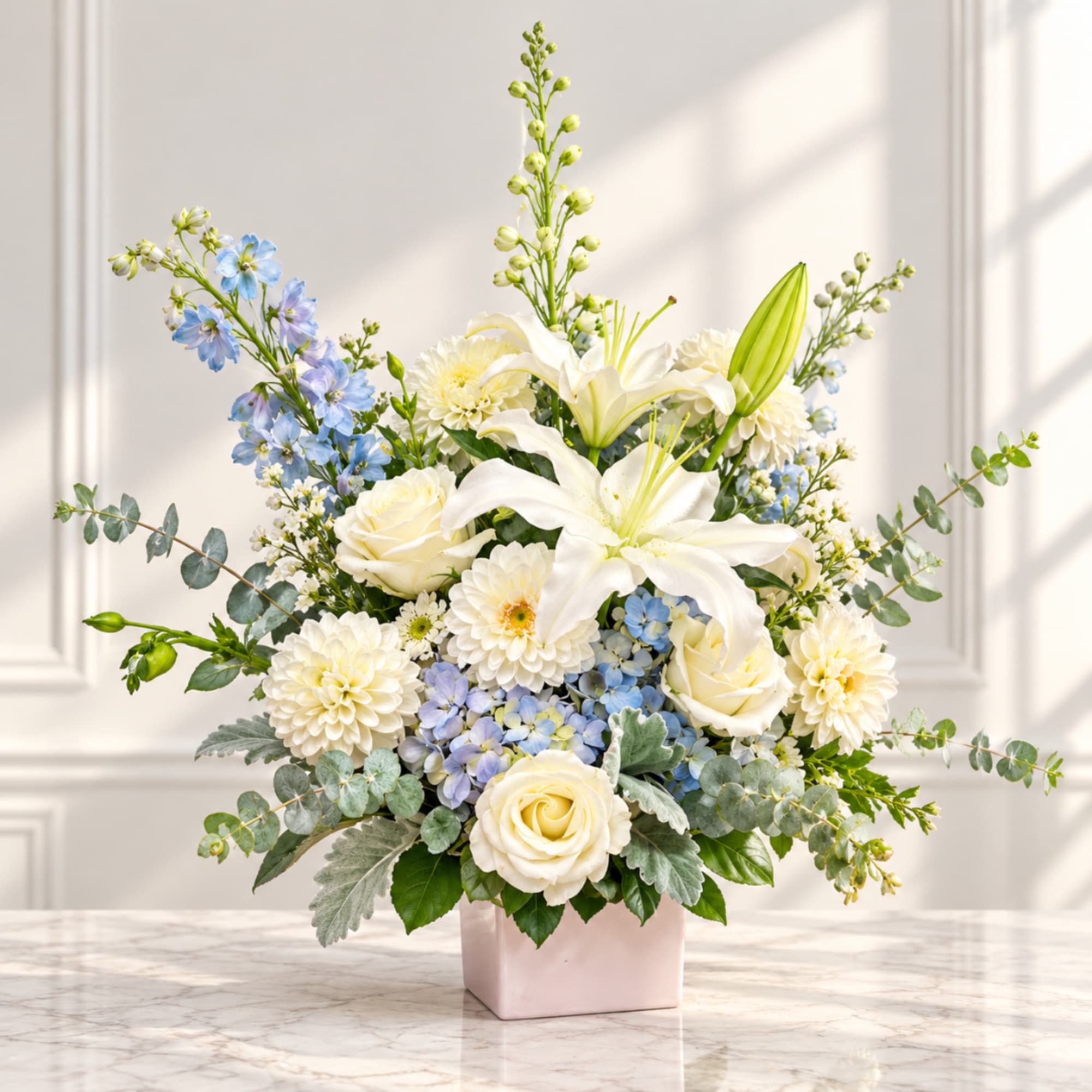 White lilies and roses in a pink vase with blue flowers
