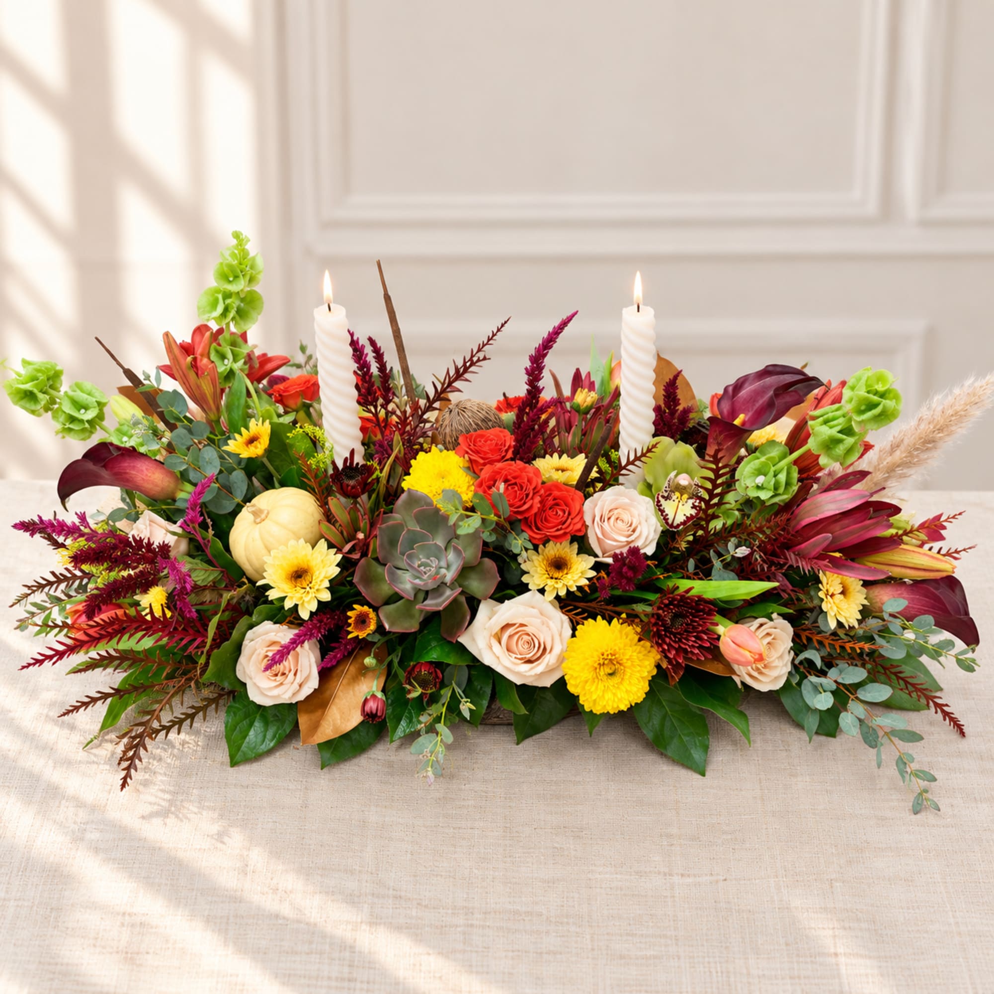 Low floral centerpiece with roses, succulents, and two white candles
