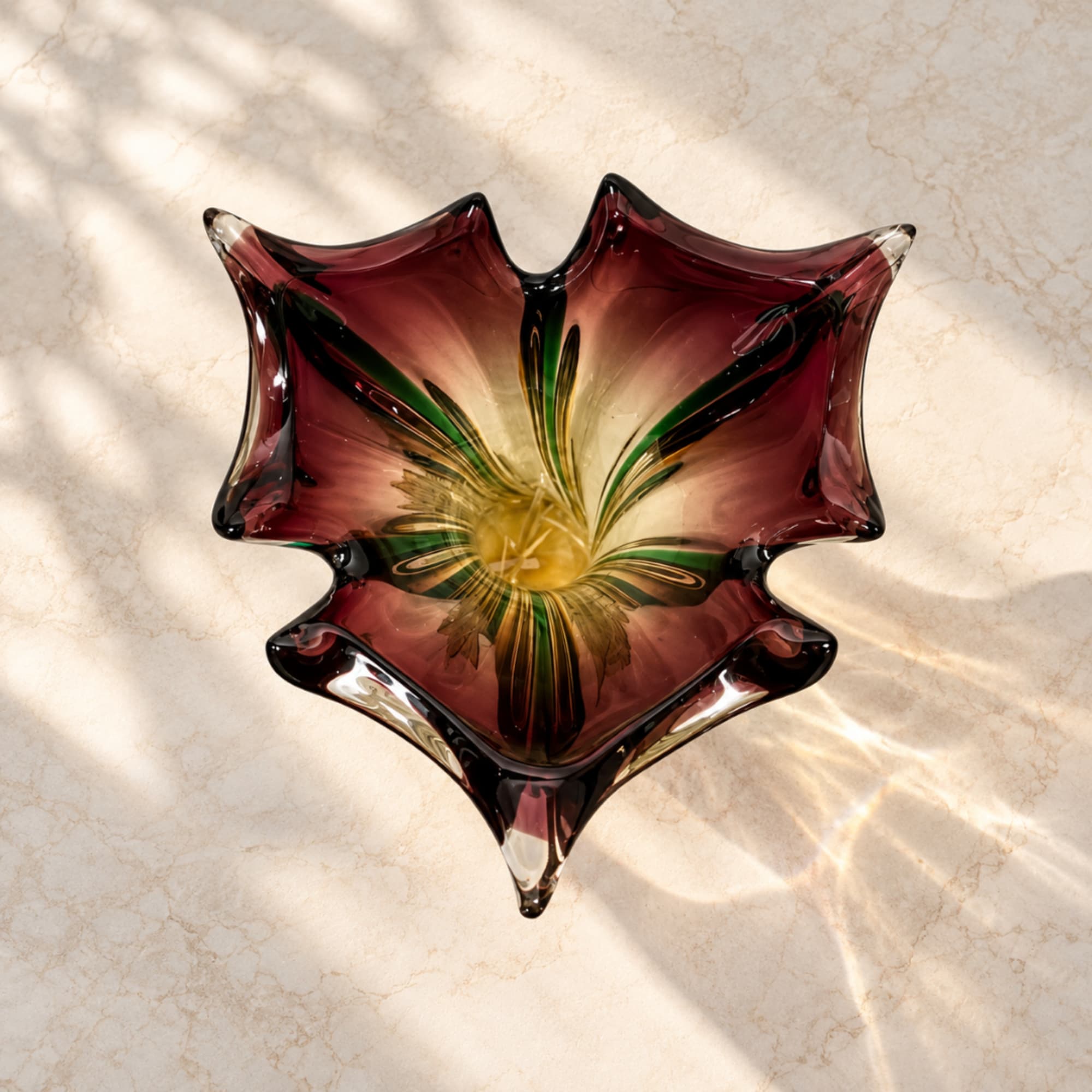 Decorative glass bowl with a floral pattern in burgundy, green, and yellow