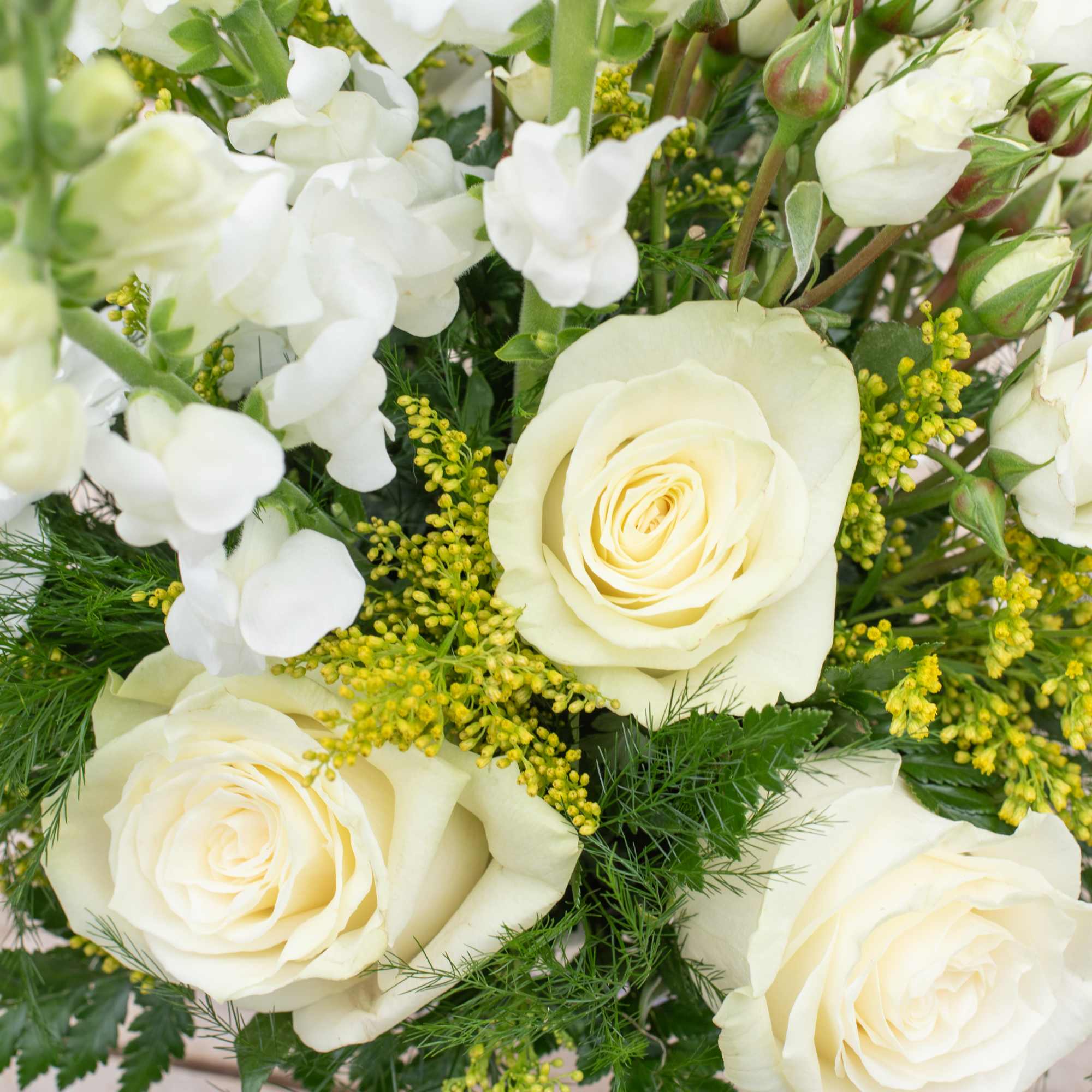 White roses and snapdragons with yellow filler flowers