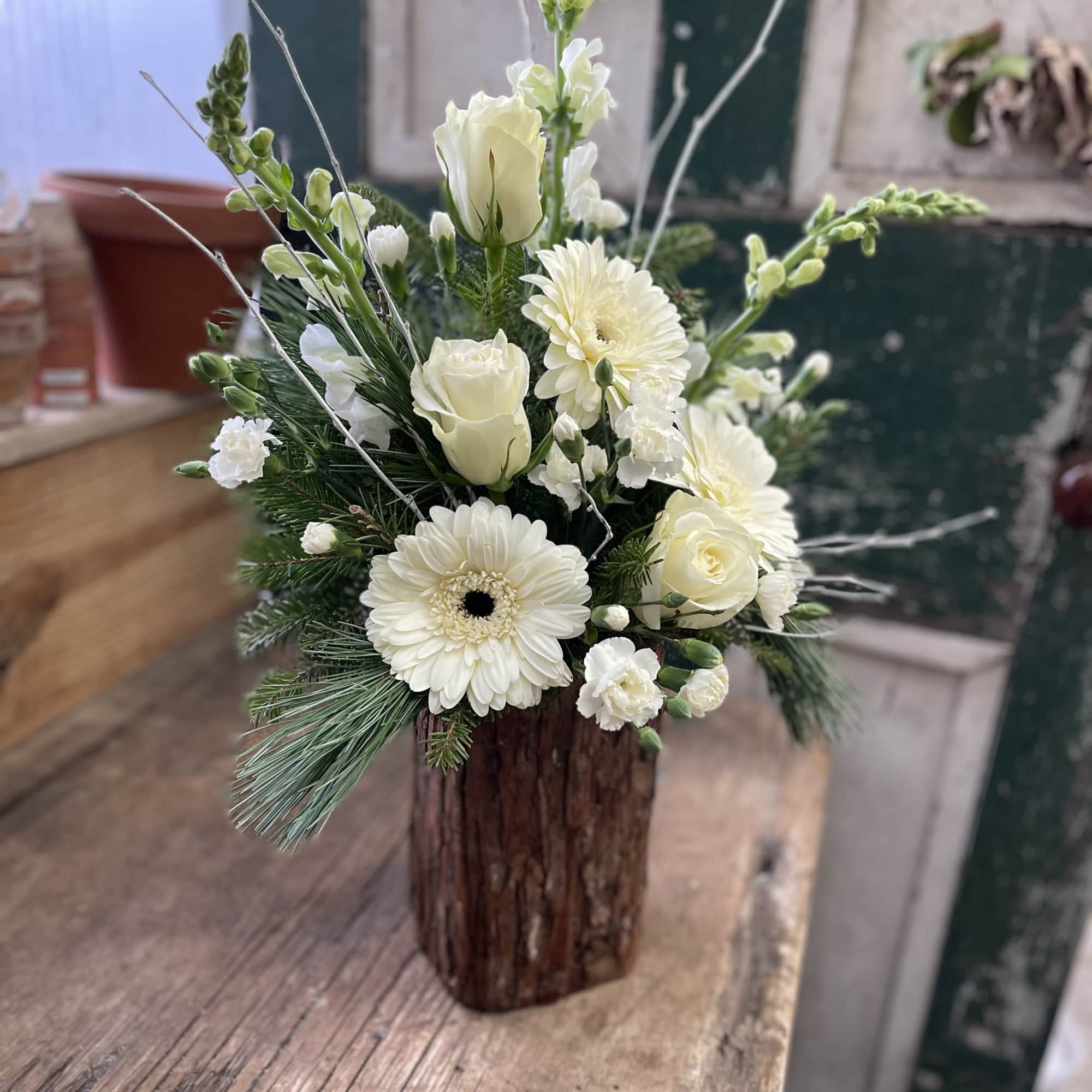 White floral arrangement in a rustic wooden vase