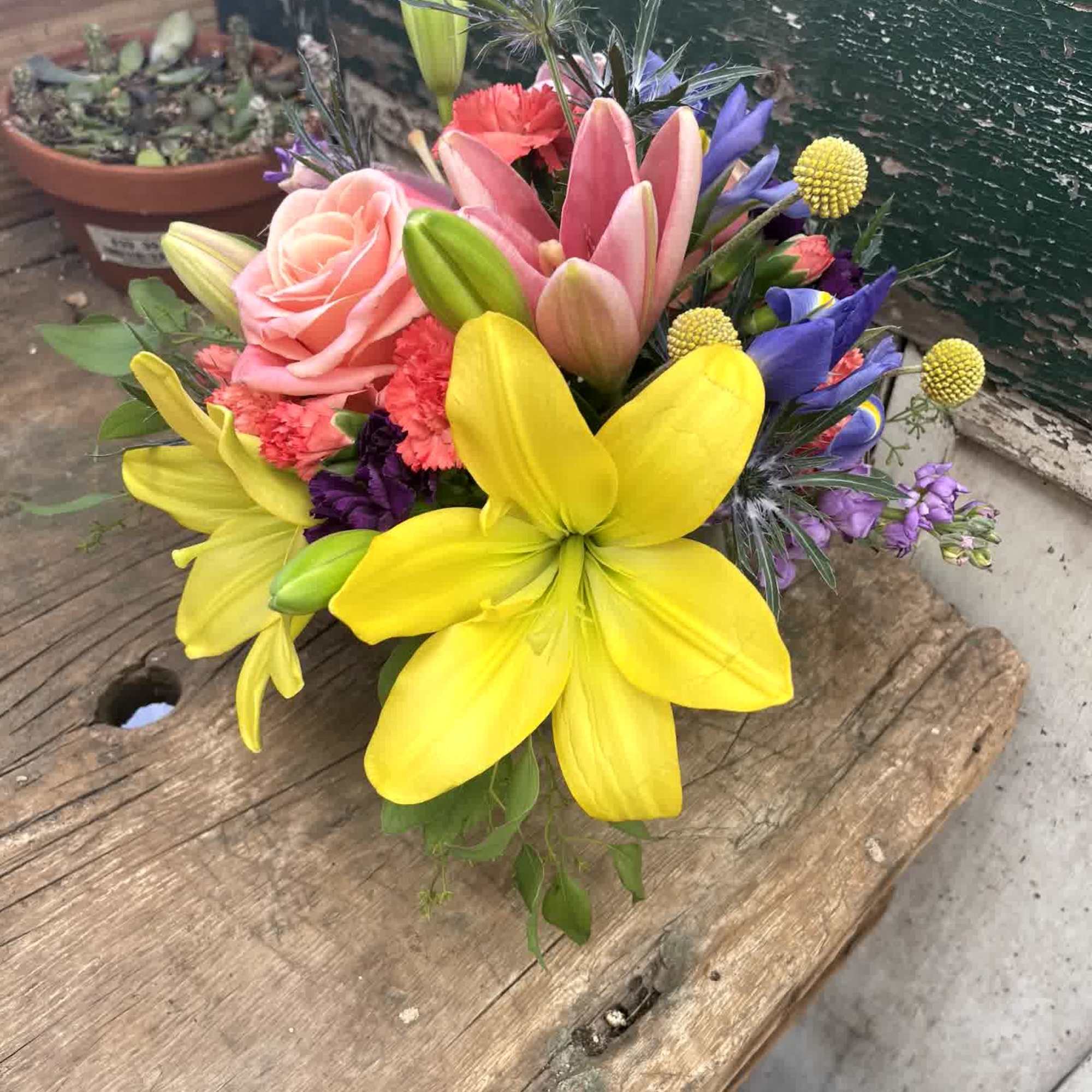 Bright mixed bouquet with yellow lilies, pink roses, and purple flowers