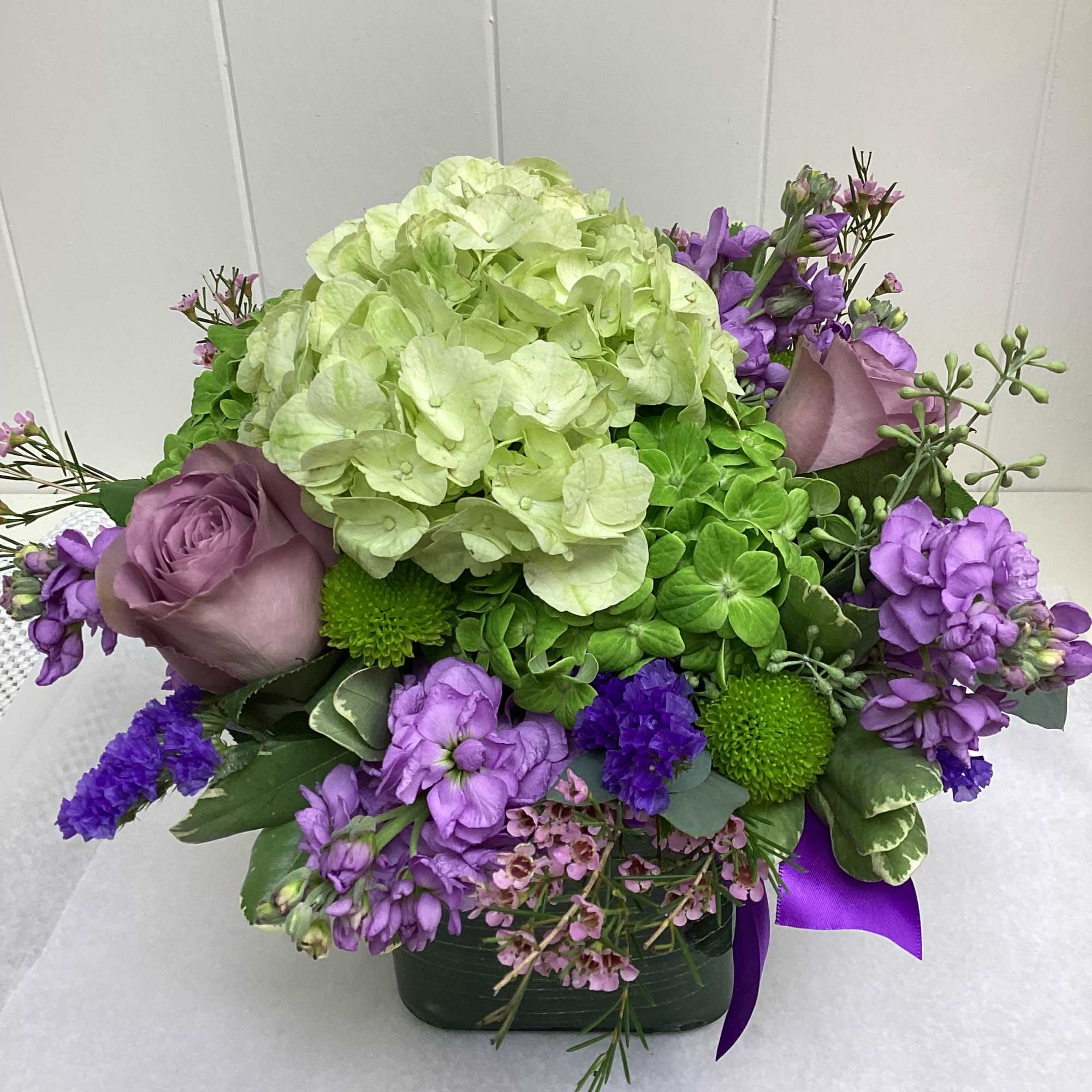 This bright and fun arrangement is made up of light green hydrangea