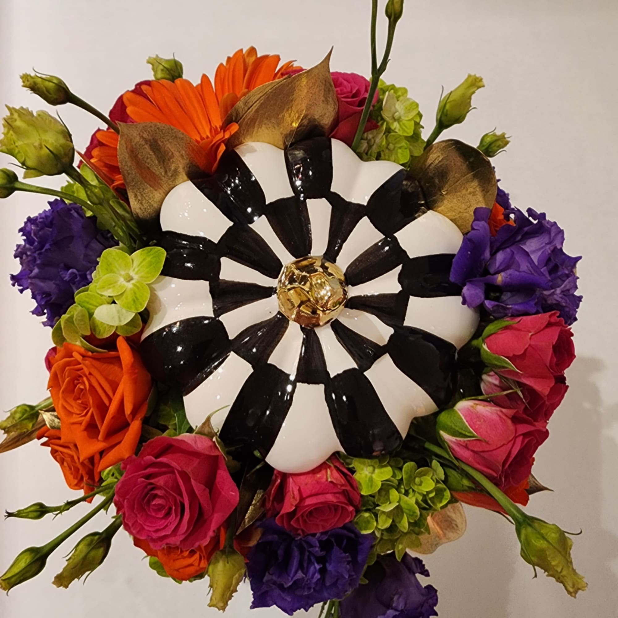 Round bouquet with roses, lisianthus, and a black-and-white decorative center
