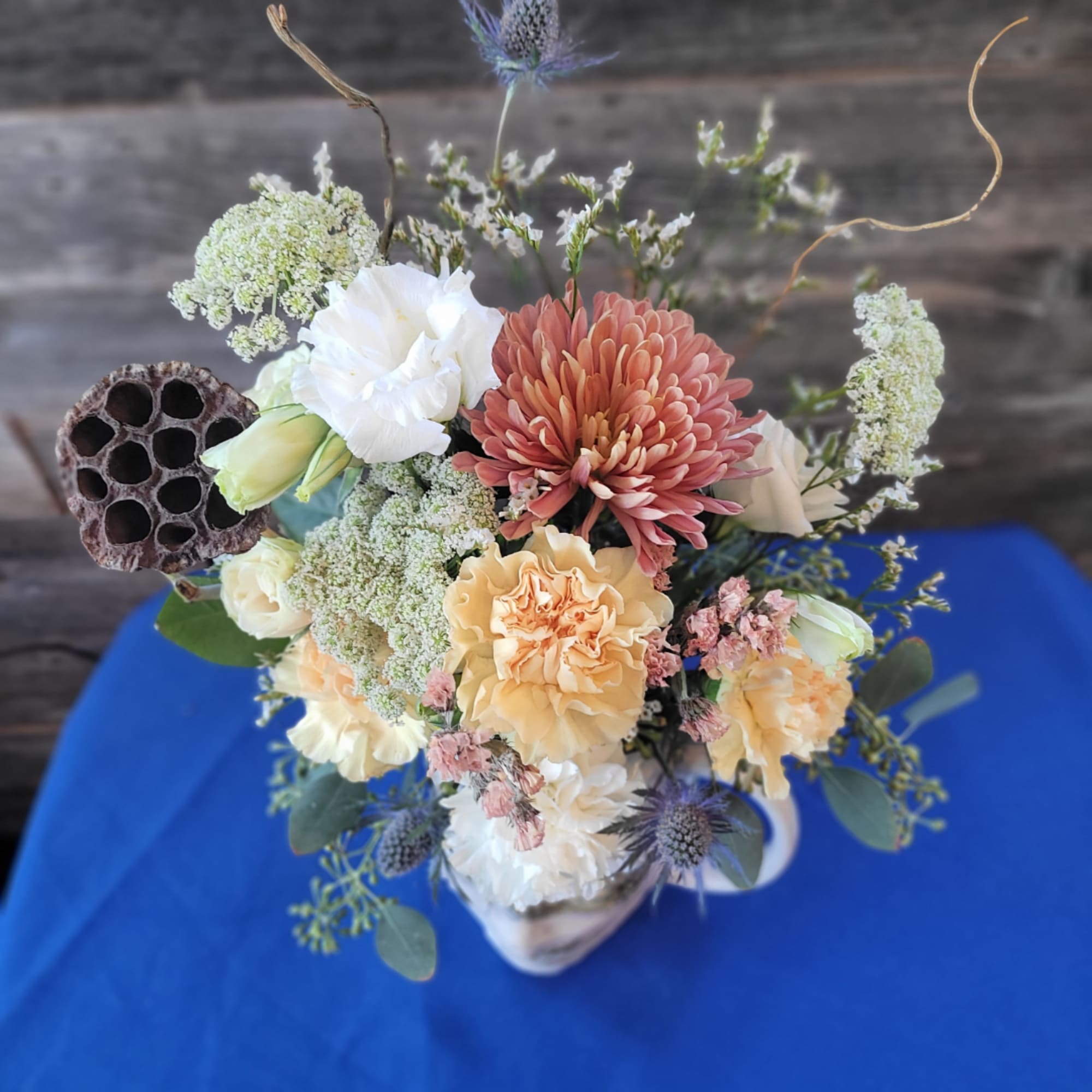 Mixed bouquet in a white vase with peach, white, and pink blooms