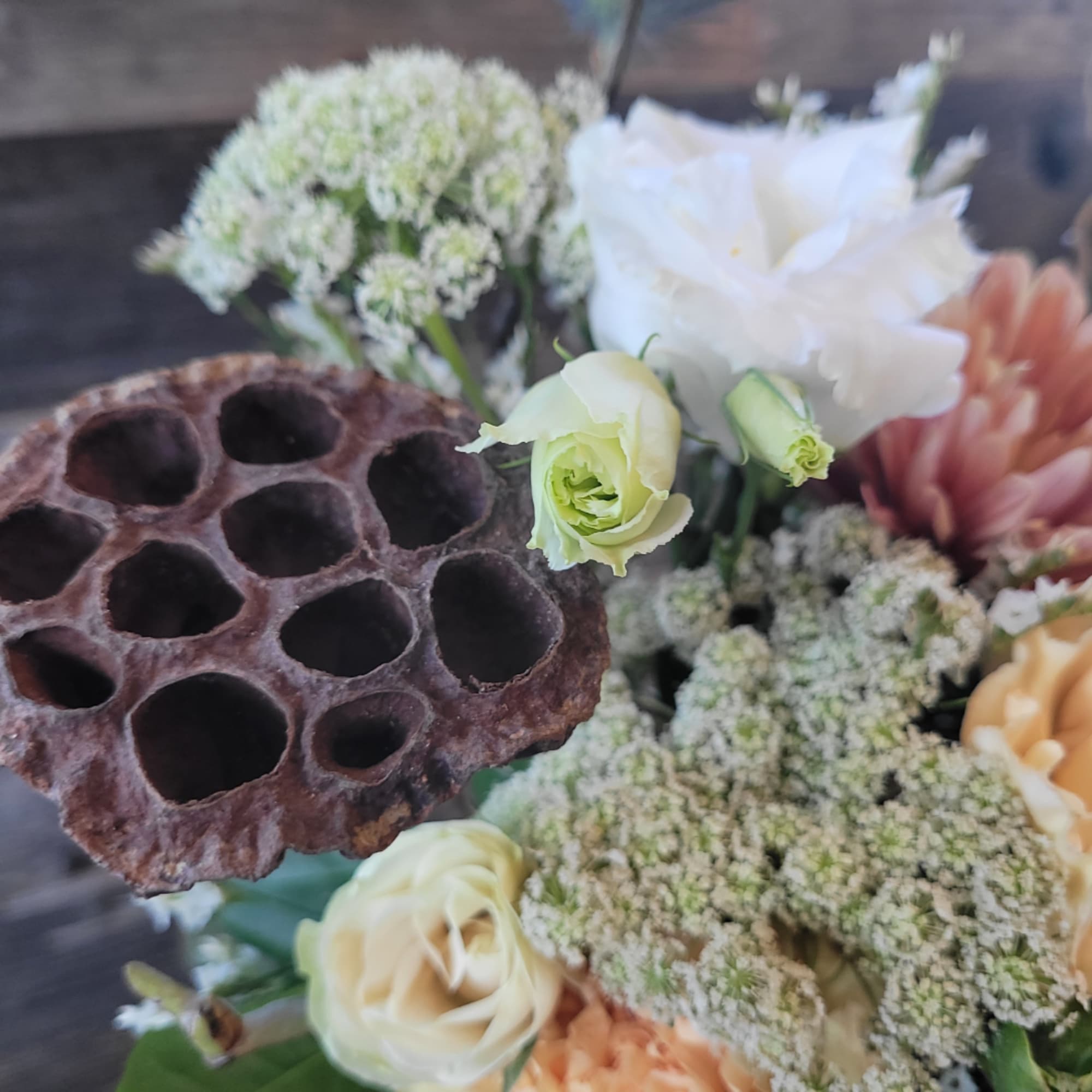Mixed bouquet with white and peach flowers and a dried seed pod