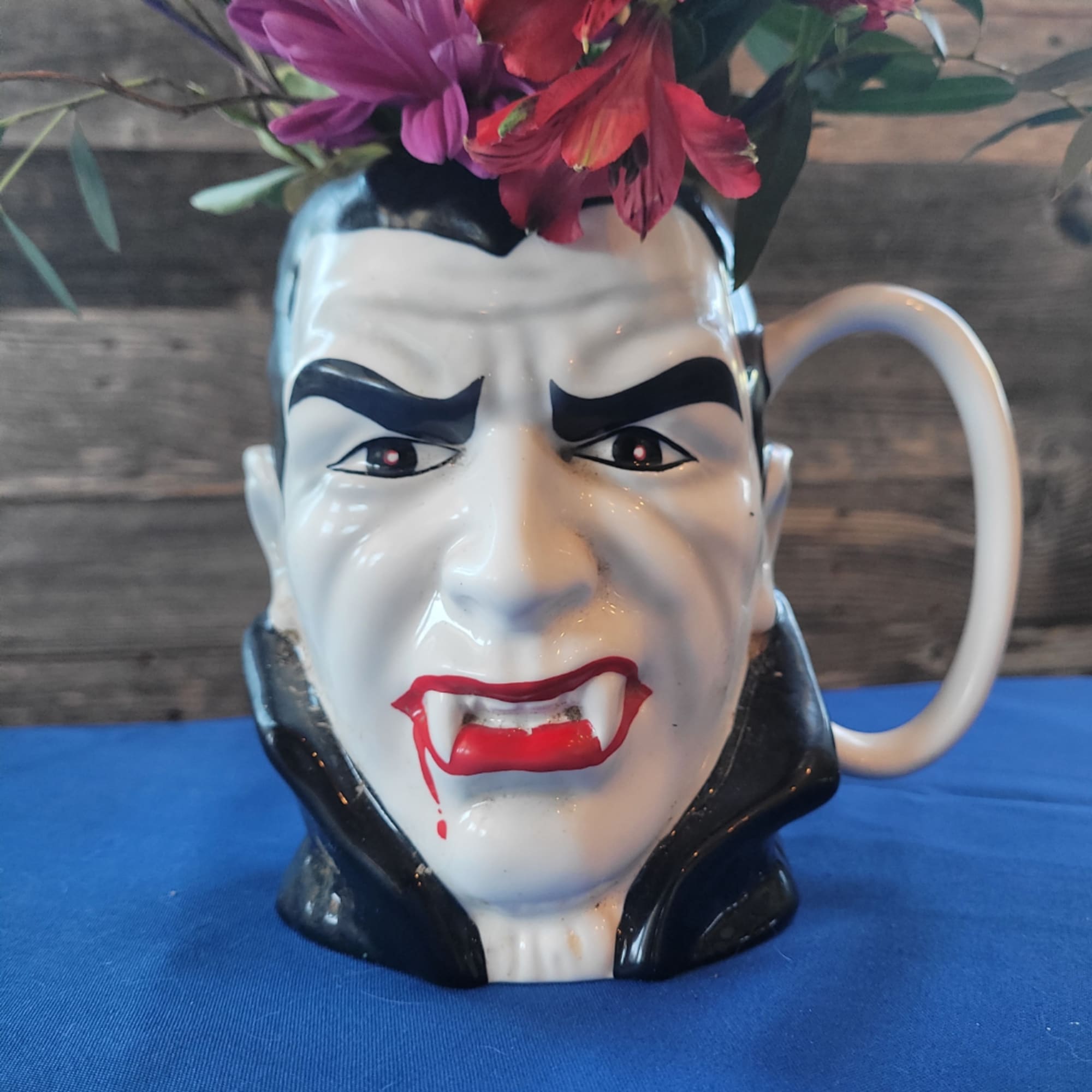 Vampire face mug holding pink and red flowers