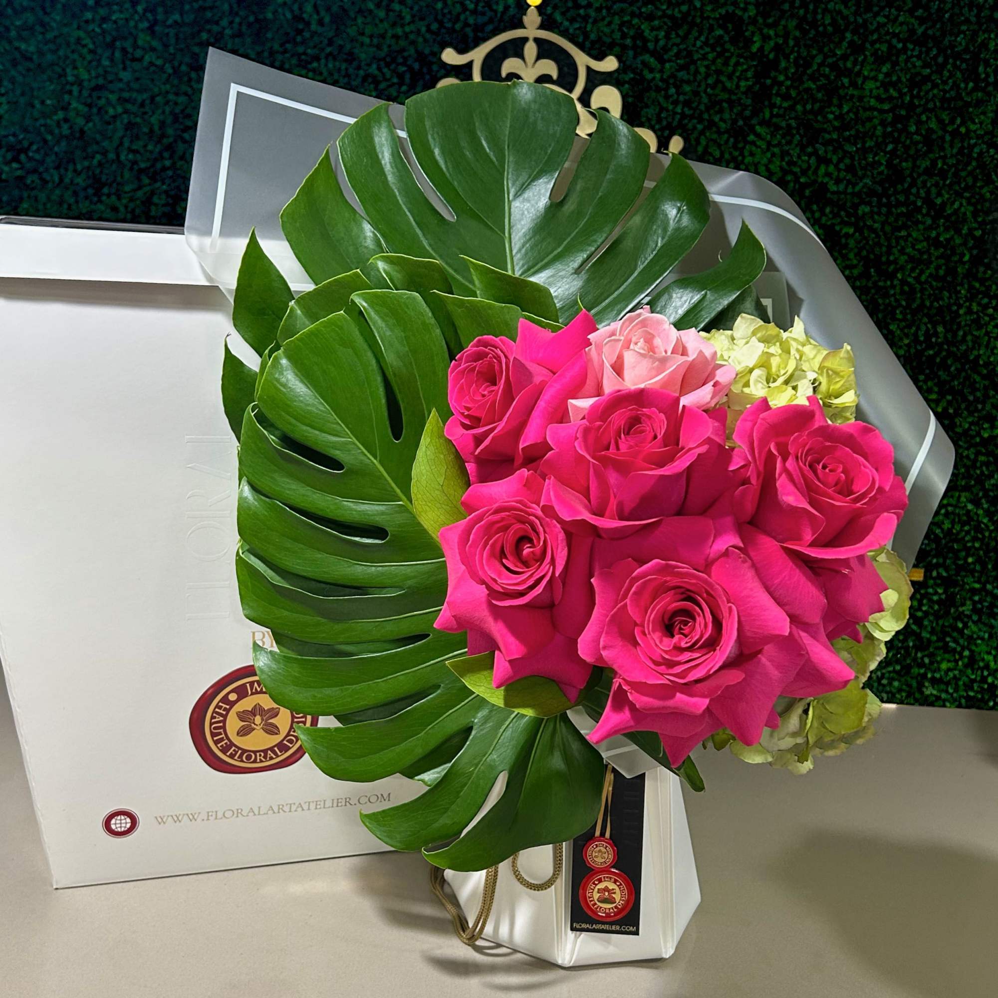 Bouquet of hot pink and pale pink roses with large tropical leaves