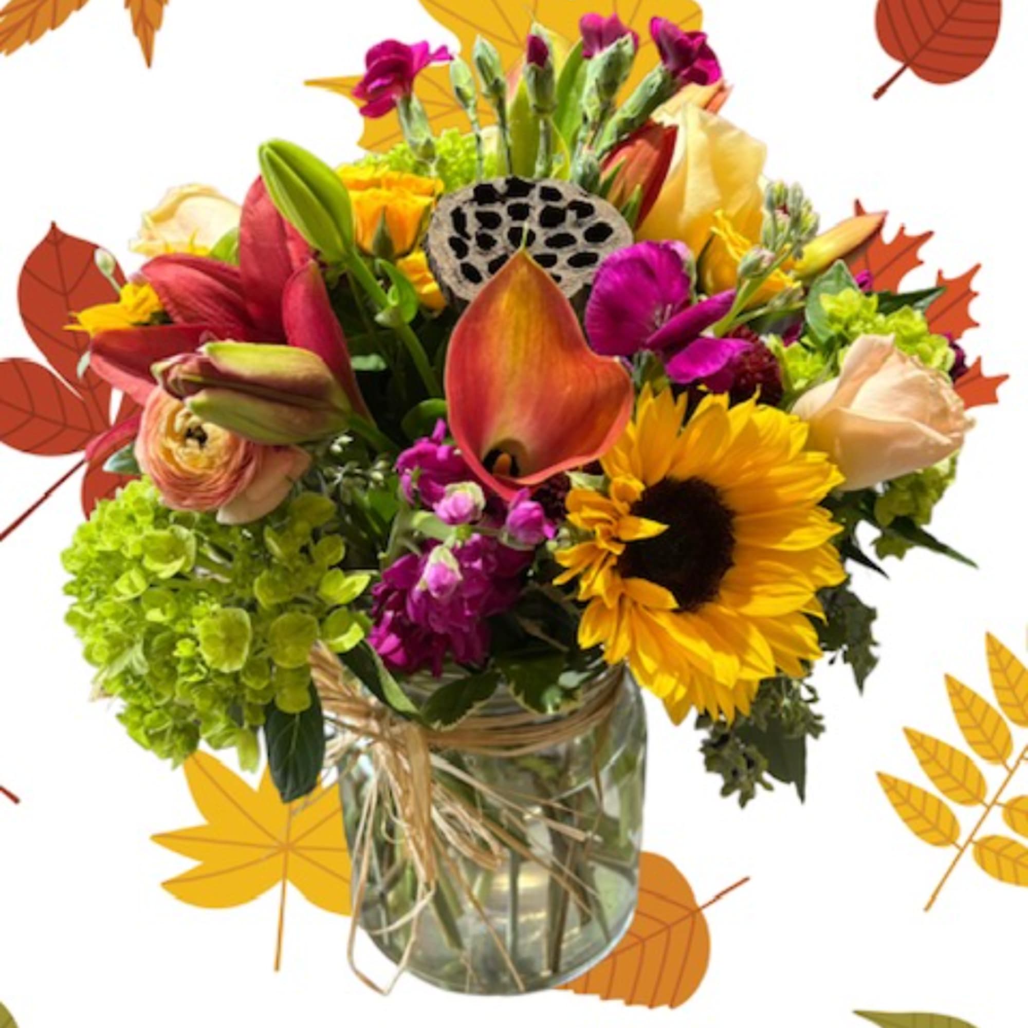 Mixed bouquet in a glass vase with sunflowers, lilies, and bright fall colors