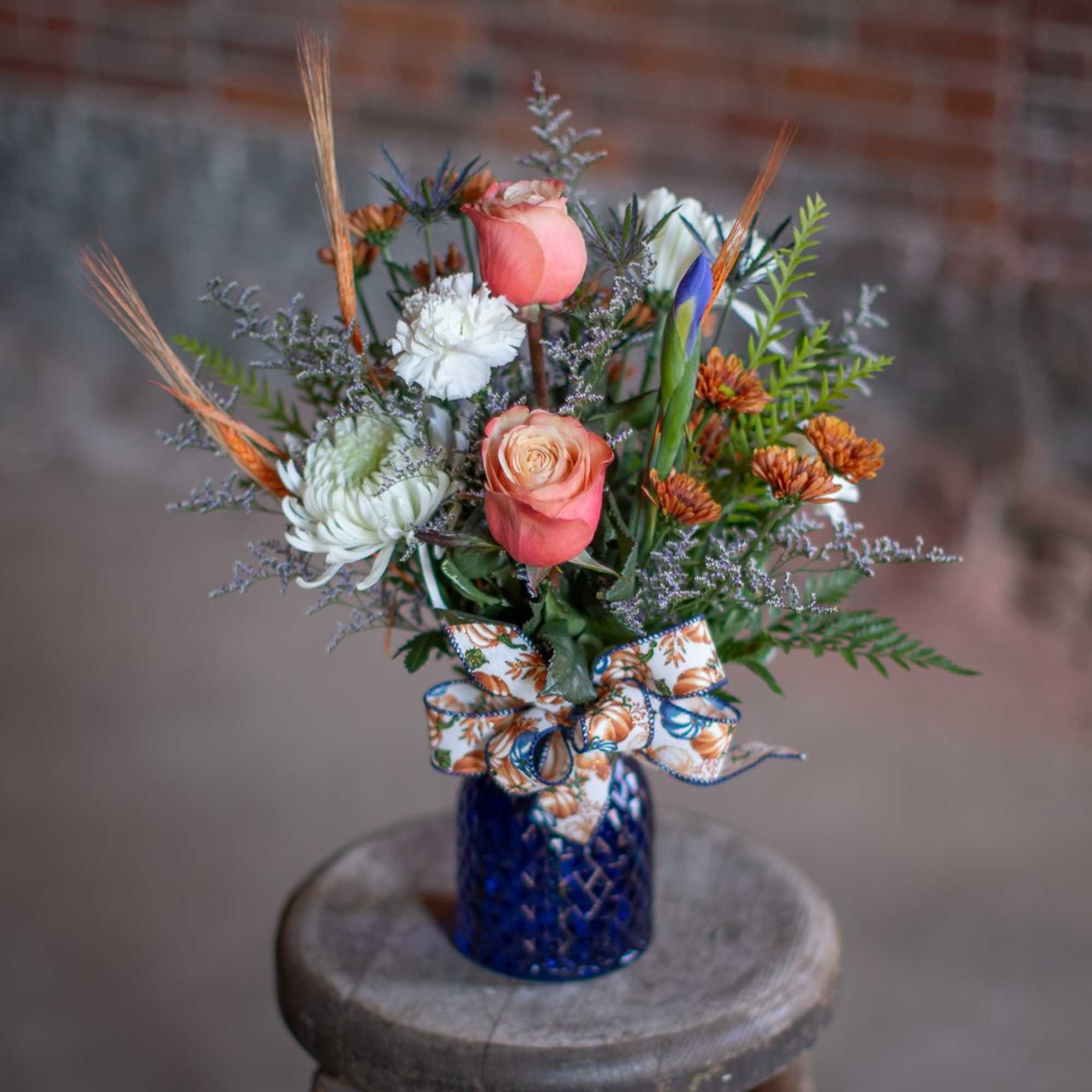 Mixed bouquet in a blue vase with pink roses and white blooms