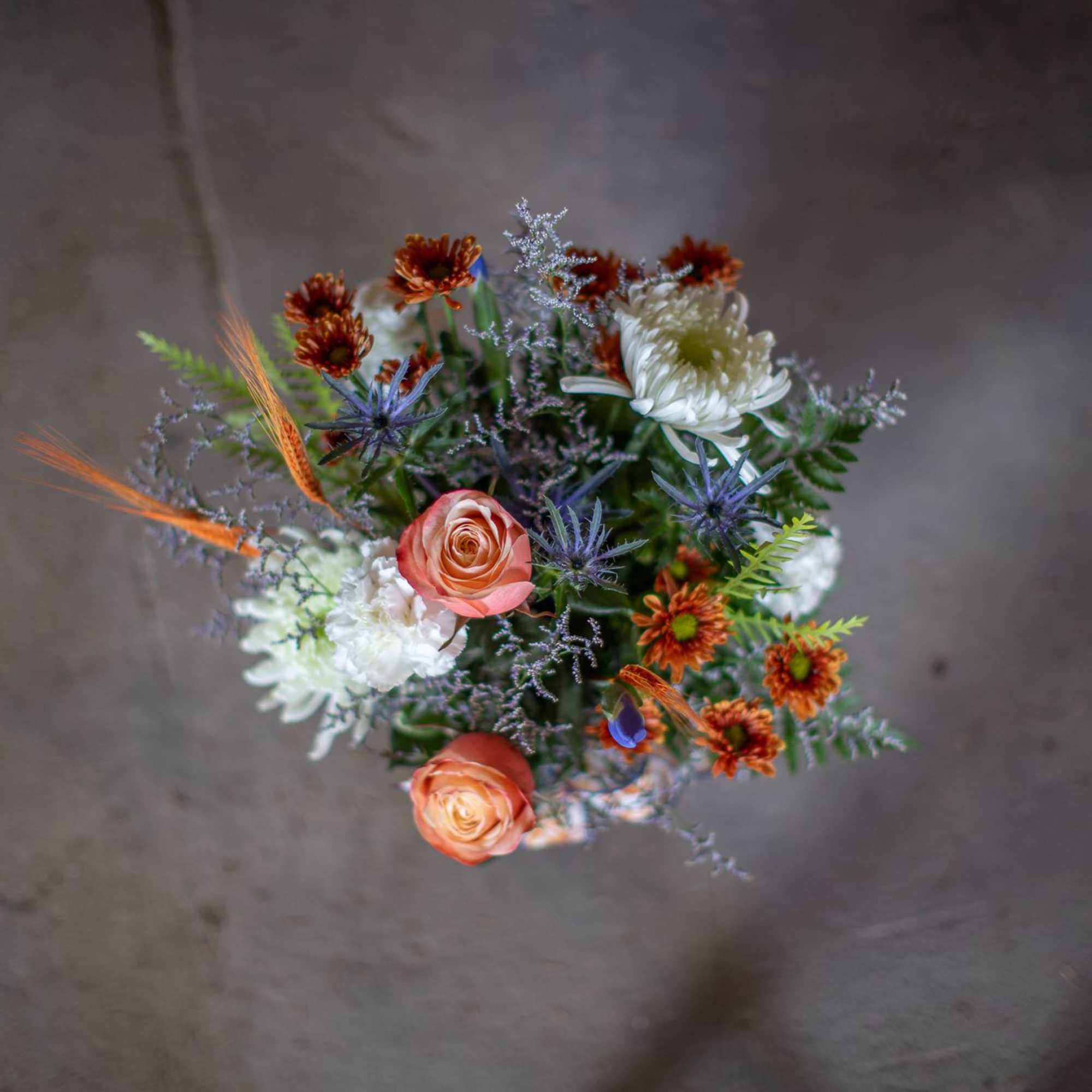 Mixed bouquet with peach roses, white blooms, and orange accents