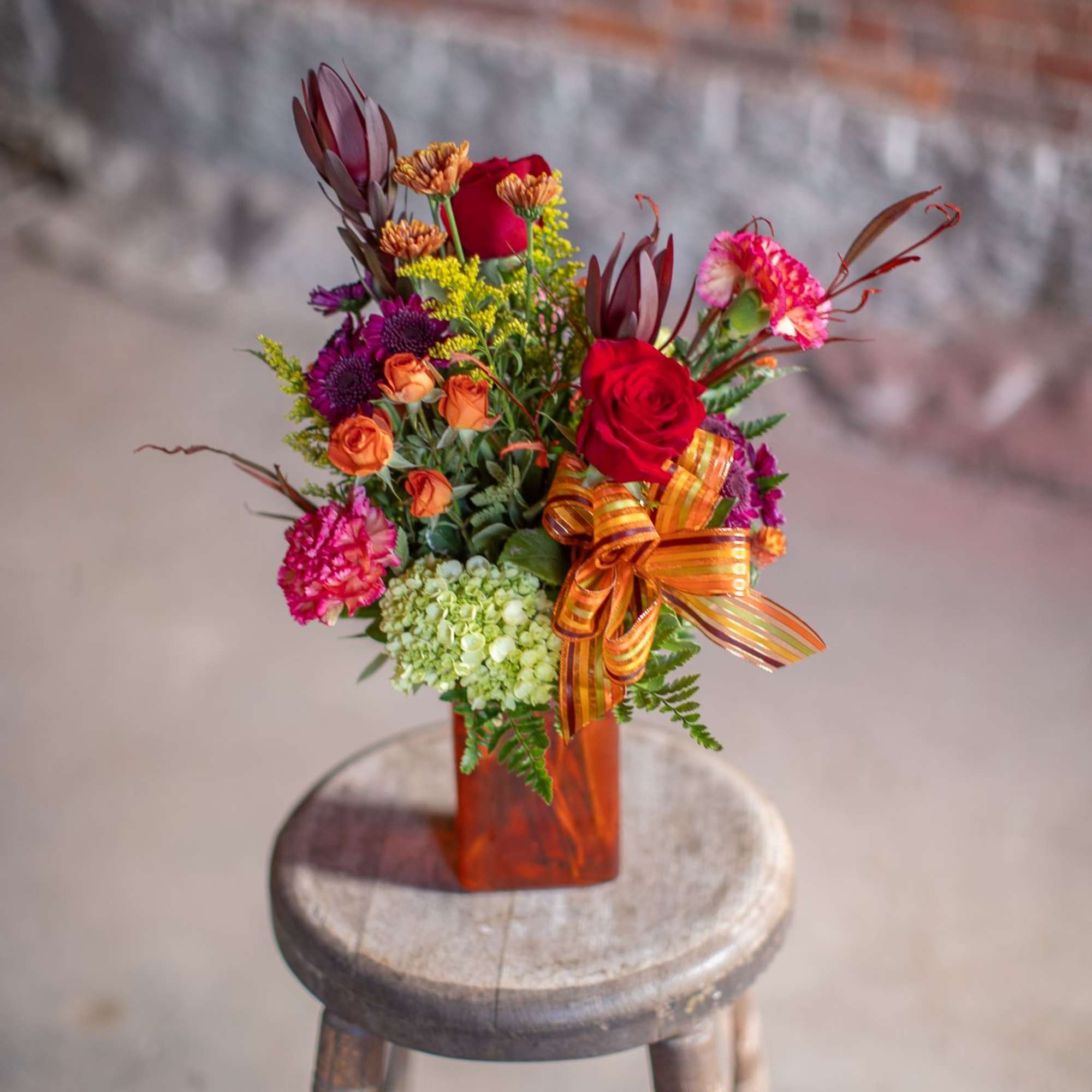 A rectangular shaped vase in an autumnal hue (orange, green, rust, or